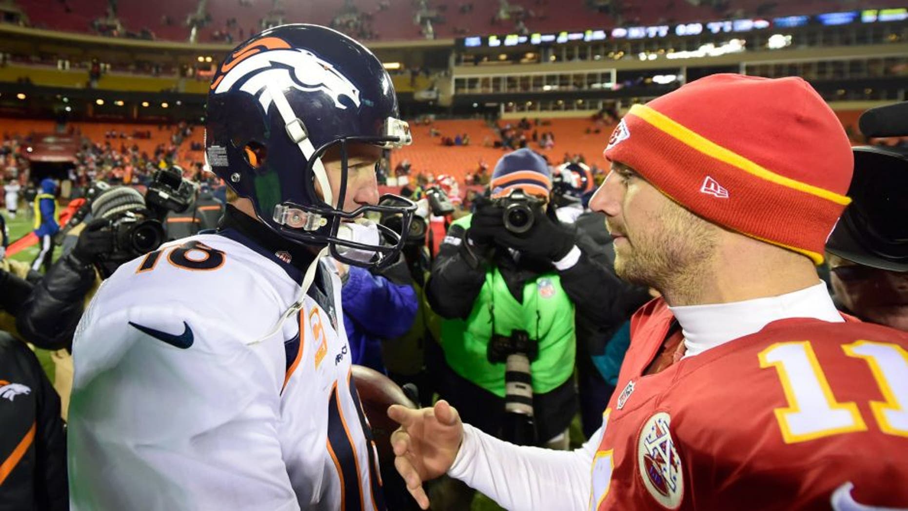 Nov 30, 2014; Kansas City, MO, USA; Denver Broncos quarterback Peyton Manning (18) greets Kansas City Chiefs quarterback Alex Smith (11) following the game at Arrowhead Stadium. The Broncos defeated the Chiefs 29-16. Mandatory Credit: Ron Chenoy-USA TODAY Sports