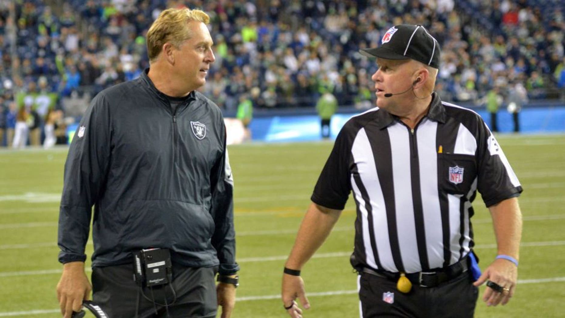 Sep 3, 2015; Seattle, WA, USA; Oakland Raiders coach Jack Del Rio (left) discusses a ruling by field judge Steve Zimmer (33) during the preseason game against the Seattle Seahawks at CenturyLink Field. Mandatory Credit: Kirby Lee-USA TODAY Sports