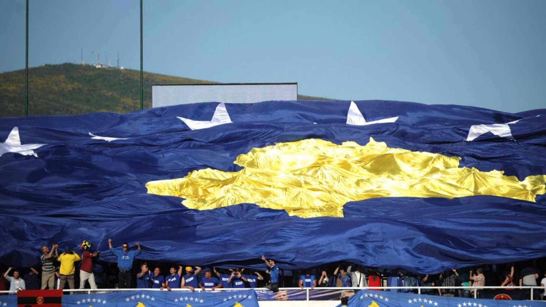 Supporters hold up a giant Kosovo national football team flag during a friendly football match between Kosovo and Turkey in the town of Mitrovica, Serbia, on May 21, 2014. AFP PHOTO / ARMEND NIMANI (Photo credit should read ARMEND NIMANI/AFP/Getty Images)