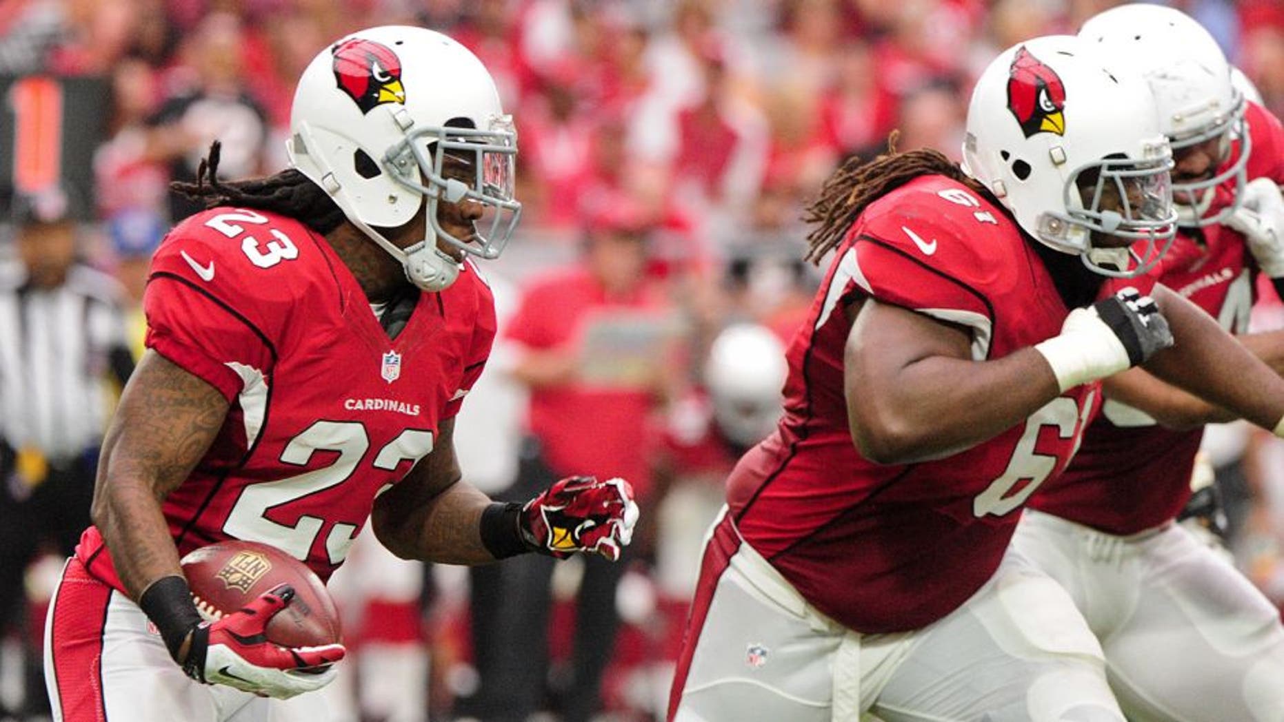Sep 13, 2015; Glendale, AZ, USA; Arizona Cardinals running back Chris Johnson (23) carries the ball behind guard Jonathan Cooper (61) during the first half against the New Orleans Saints at University of Phoenix Stadium. Mandatory Credit: Matt Kartozian-USA TODAY Sports