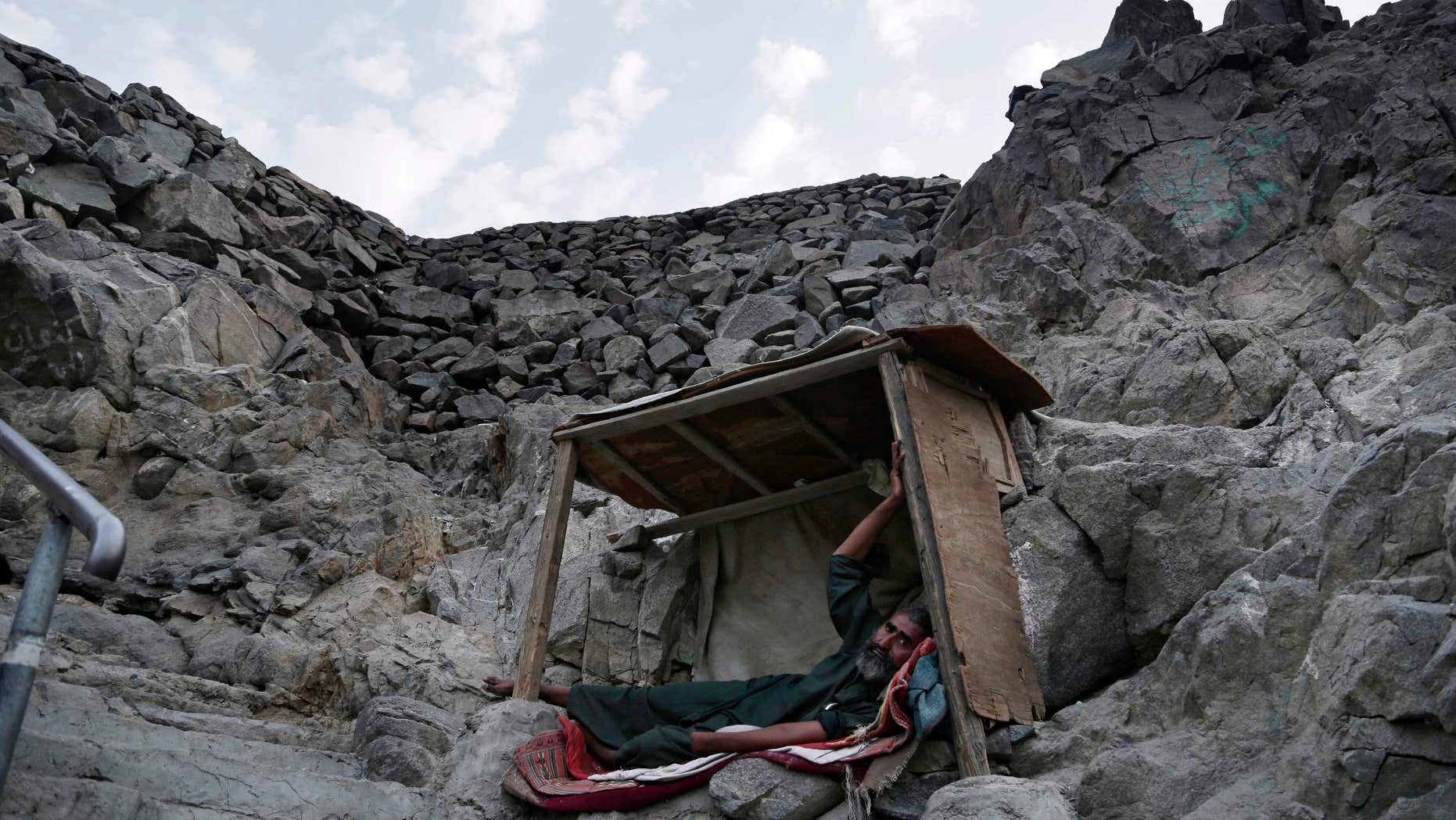 In this Friday, Sept. 9, 2016 photo, a Pakistani beggar who sleeps on Noor Mountain, where Prophet Muhammad received his first revelation from God to preach Islam, poses for a portrait, on the outskirts of Mecca, Saudi Arabia.
