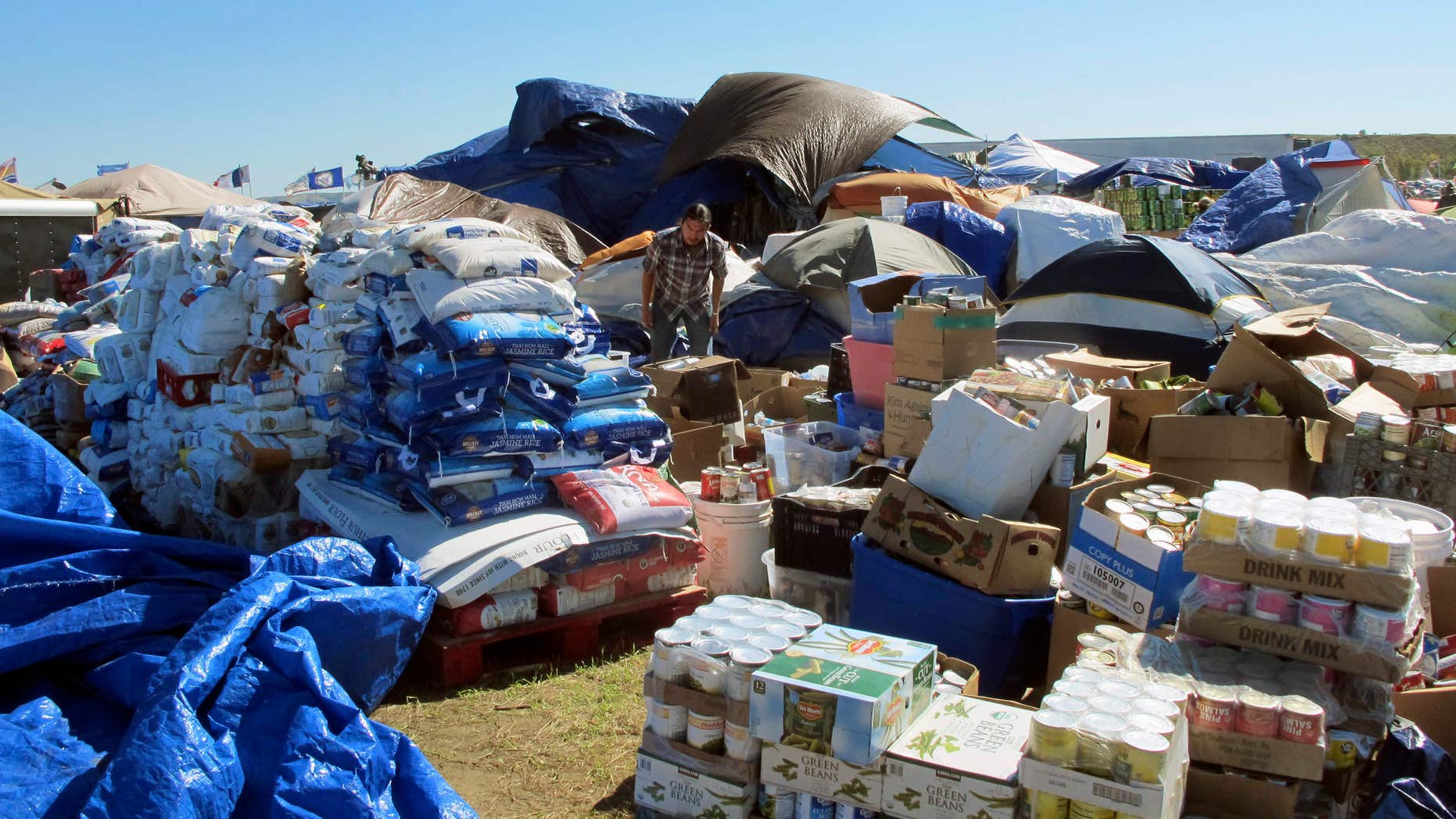 In this Wednesday, Sept. 14, 2016, photo, a volunteer sorts through donated food near the Standing Rock Sioux Reservation in North Dakota.
