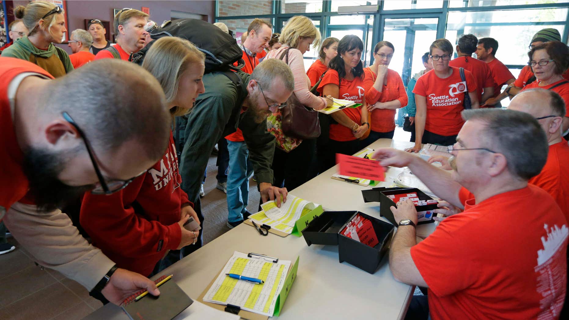 Sept. 15, 2015: Members of the Seattle Education Association, the union that represents striking teachers from the Seattle School District, sign in to receive voting cards as they arrive at a meeting hall in Seattle to discuss a tentative contract agreement that was reached with the district Tuesday morning, the fifth day of the strike.