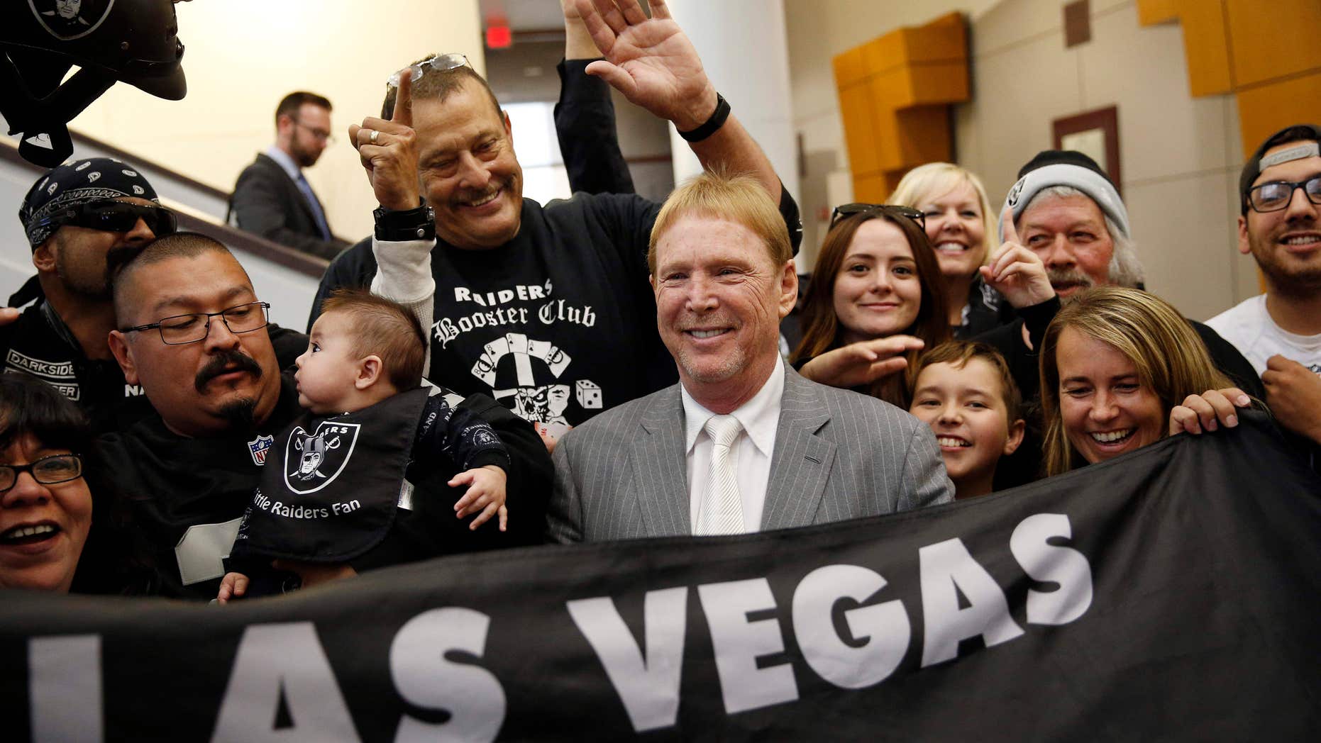 FILE - In this April 28, 2016 file photo, Oakland Raiders owner Mark Davis, center, meets with Raiders fans after speaking at a meeting of the Southern Nevada Tourism Infrastructure Committee in Las Vegas.