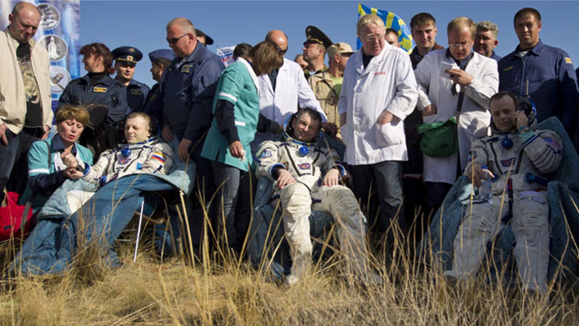In this image provided by NASA Expedition 28 Commander Andrei Borisenko, left, Flight Engineers Alexander Samokutyayev, center, and Ron Garan, sit in chairs outside the Soyuz Capsule just minutes after they landed in a remote area outside the town of Zhezkazgan, Kazakhstan.