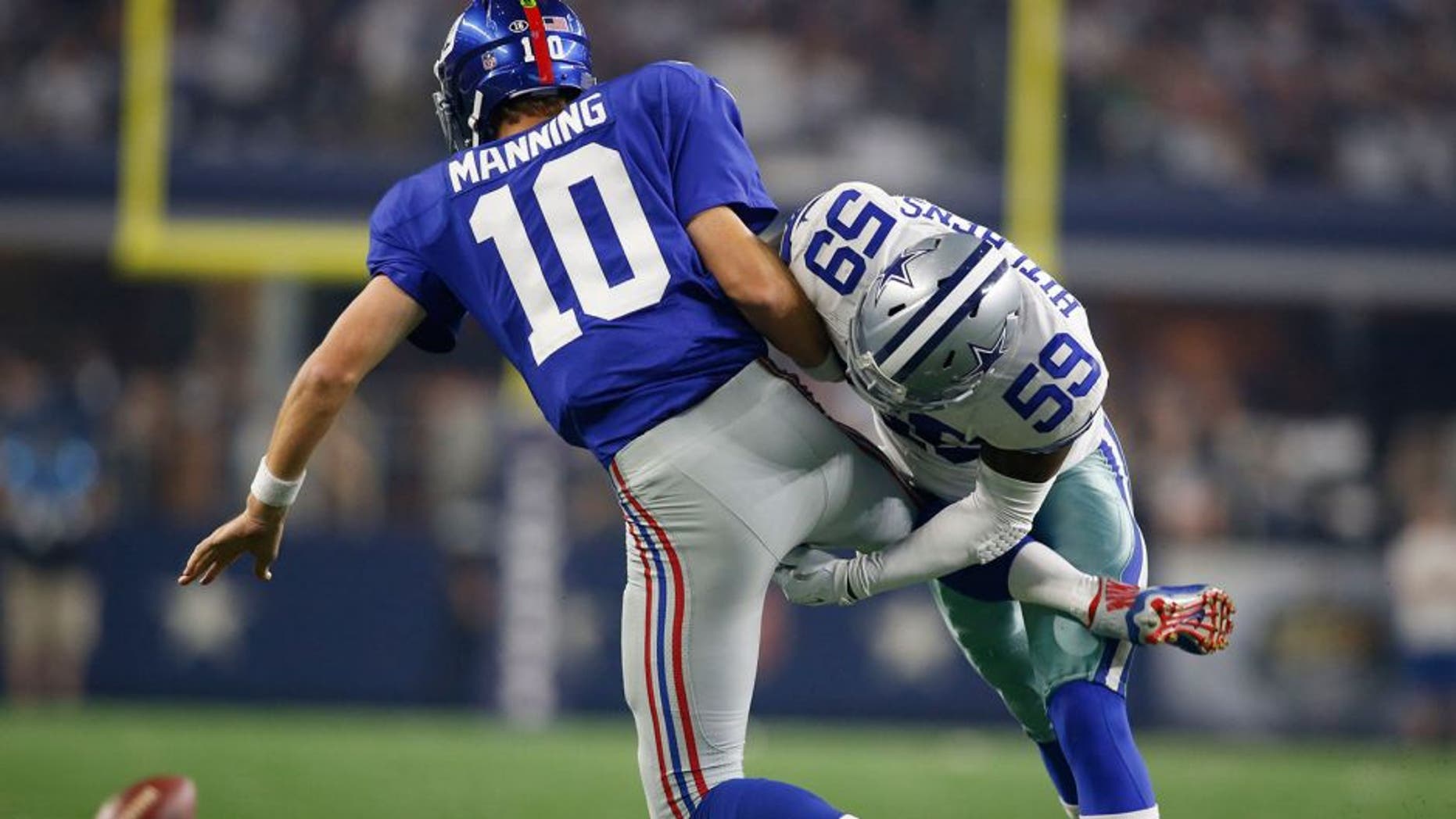 Sep 13, 2015; Arlington, TX, USA; New York Giants quarterback Eli Manning (10) is hit after he throws a pass in the second quarter by Dallas Cowboys outside linebacker Anthony Hitchens (59) at AT&T Stadium. Mandatory Credit: Tim Heitman-USA TODAY Sports