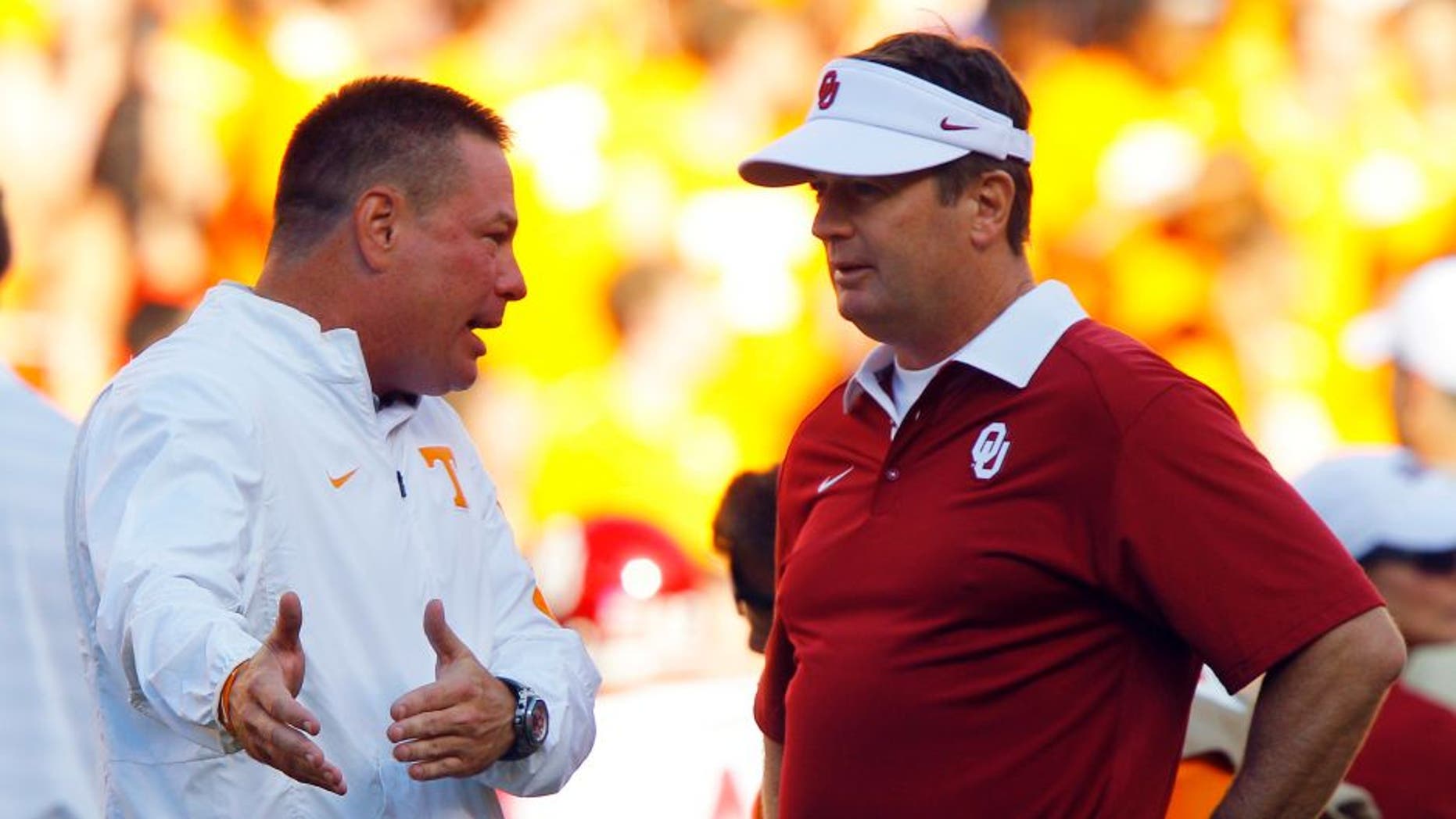 Tennessee head coach Butch Jones, left, talks with Oklahoma head coach Bob Stoops before an NCAA college football game, Saturday, Sept. 12, 2015 in Knoxville, Tenn. (AP Photo/Wade Payne)