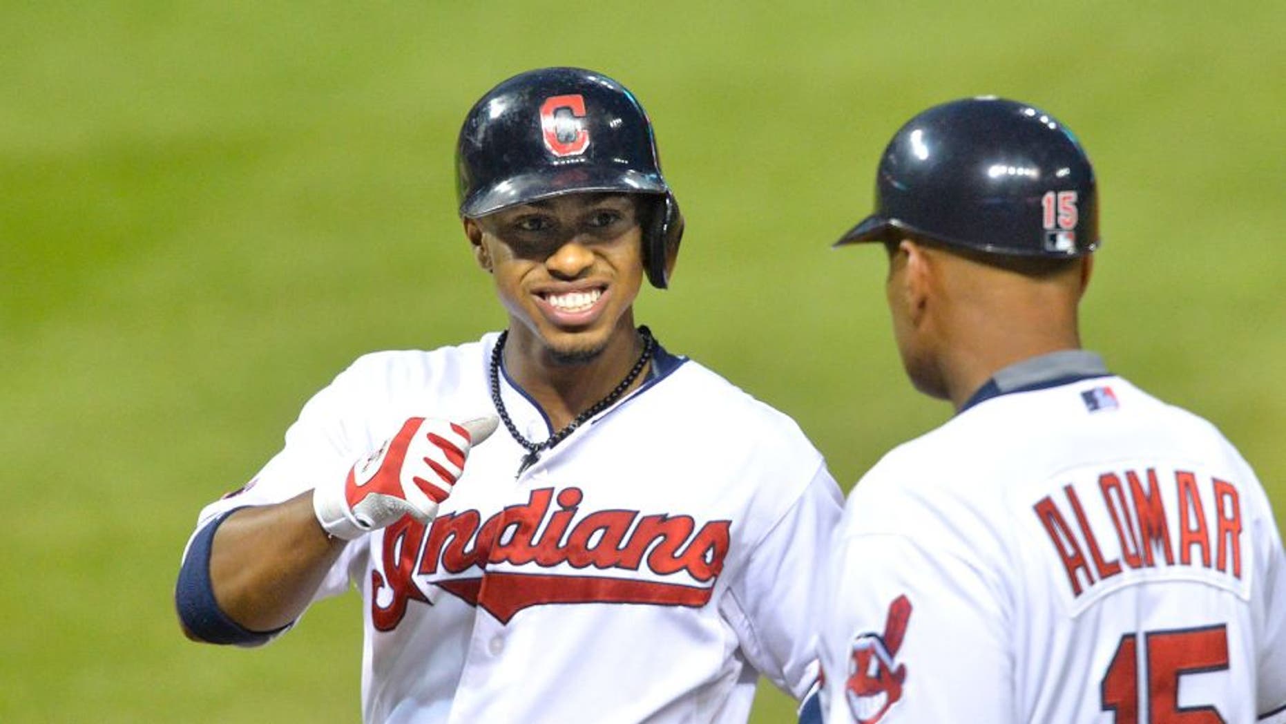 Sep 16, 2015; Cleveland, OH, USA; Cleveland Indians shortstop Francisco Lindor (12) celebrates his RBI single with first base coach Sandy Alomar Jr. (15) in the second inning against the Kansas City Royals at Progressive Field. Mandatory Credit: David Richard-USA TODAY Sports