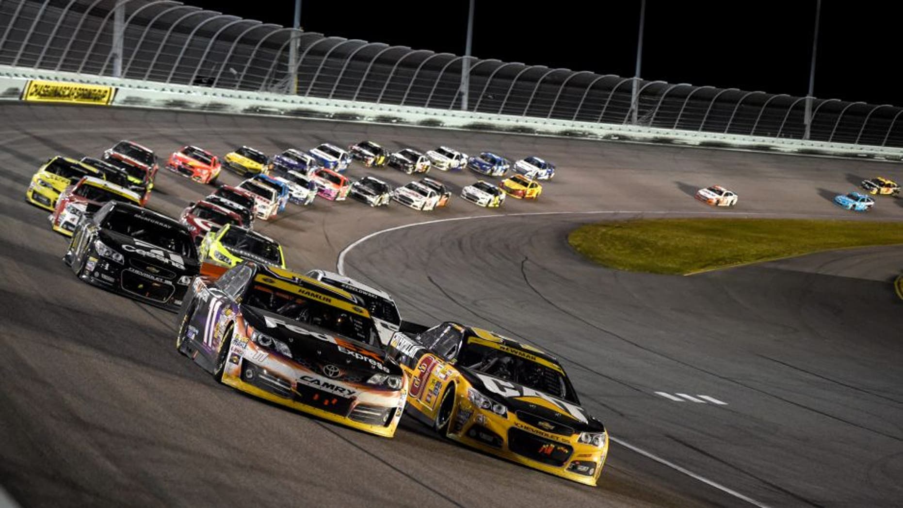 HOMESTEAD, FL - NOVEMBER 16: Denny Hamlin, driver of the #11 FedEx Express Toyota, races with Ryan Newman, driver of the #31 Caterpillar Chevrolet, during the NASCAR Sprint Cup Series Ford EcoBoost 400 at Homestead-Miami Speedway on November 16, 2014 in Homestead, Florida.