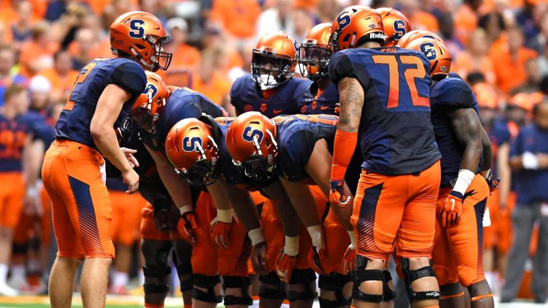 Sep 4, 2015; Syracuse, NY, USA; Syracuse Orange quarterback Eric Dungey (L) calls a play in the huddle against the Rhode Island Rams during the second quarter at the Carrier Dome. Syracuse won the game 47-0. Mandatory Credit: Rich Barnes-USA TODAY Sports