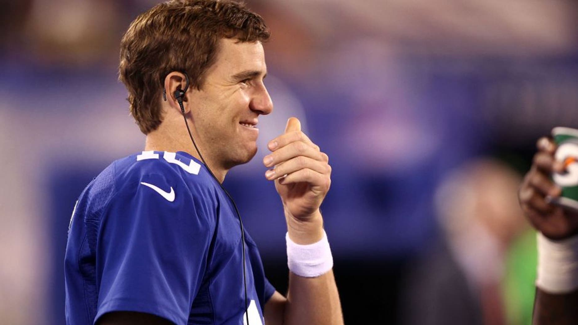 Aug 22, 2015; East Rutherford, NJ, USA; New York Giants quarterback Eli Manning (10) smiles from the sidelines during the second half against the Jacksonville Jaguars at MetLife Stadium. Mandatory Credit: Danny Wild-USA TODAY Sports