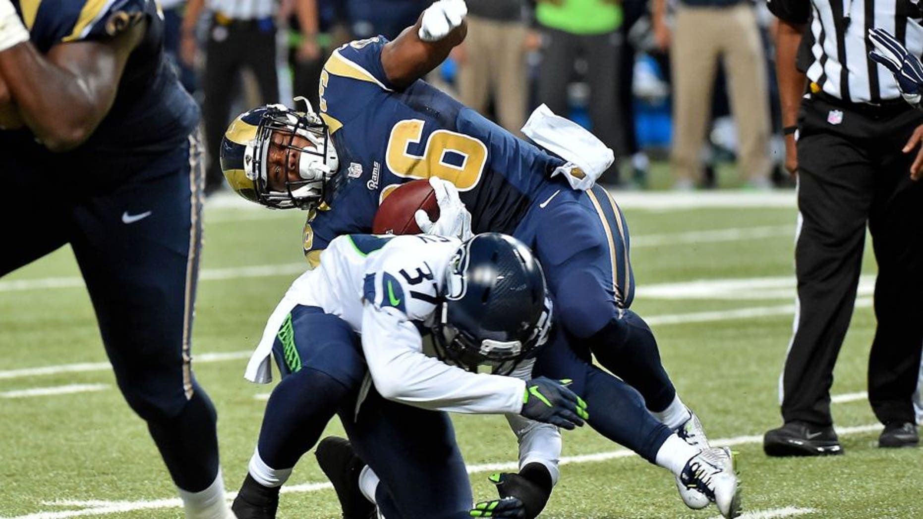 Sep 13, 2015; St. Louis, MO, USA; Seattle Seahawks free safety Dion Bailey (37) brings down St. Louis Rams running back Benny Cunningham (36) during the second half at the Edward Jones Dome. Mandatory Credit: Jasen Vinlove-USA TODAY Sports