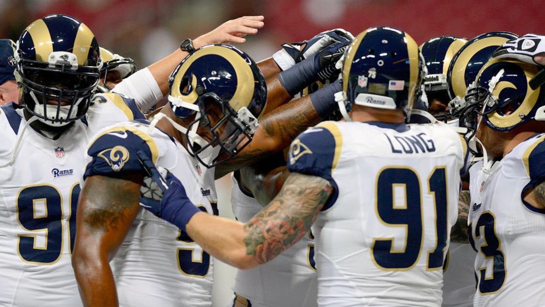 Sep 26, 2013; St. Louis, MO, USA; St. Louis Rams defensive tackle Michael Brockers (90) defensive end Robert Quinn (94) and defensive end Chris Long (91) huddle up before a game against the San Francisco 49ers at the Edward Jones Dome. Mandatory Credit: Jeff Curry-USA TODAY Sports