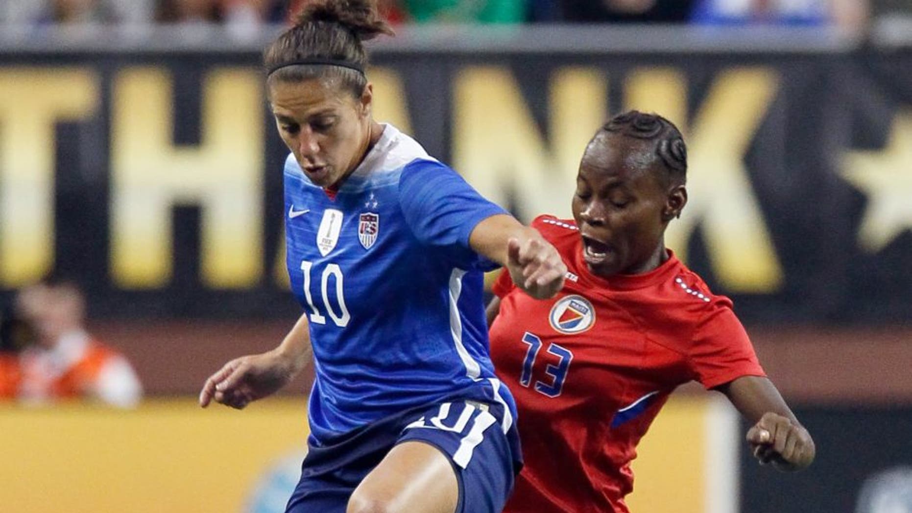 DETROIT, MI - SEPTEMBER 17: Carli Lloyd #10 of the United States tries to keep the ball away from Zila Lafleur #13 of Haiti during the first half of the U.S. Women's 2015 World Cup victory tour match at Ford Field on September 17, 2015, in Detroit, Michigan. (Photo by Duane Burleson/Getty Images)