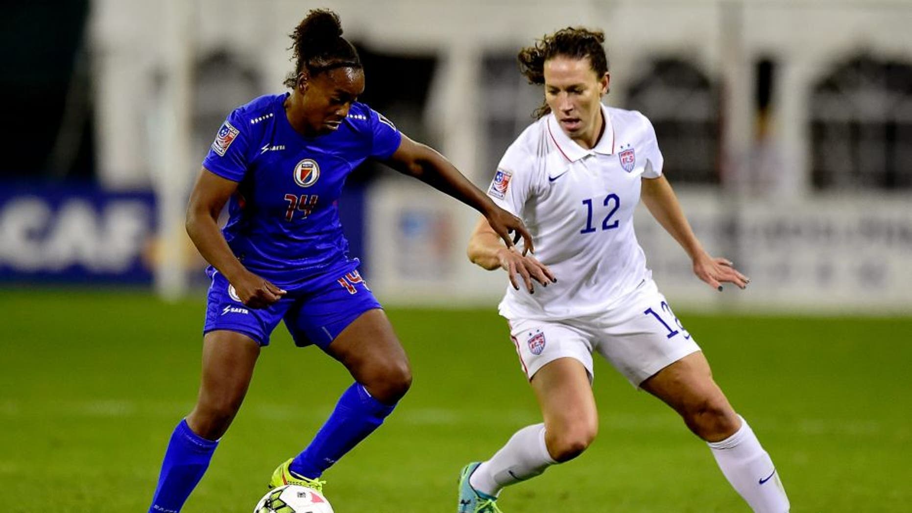 WASHINGTON, DC - OCTOBER 20: Samantha Brand #14 of Haiti battles for the ball against Lauren Holiday #12 of the United States in the first half during the 2014 CONCACAF Women's Championship at RFK Stadium on October 20, 2014 in Washington, DC. (Photo by Patrick McDermott/Getty Images)