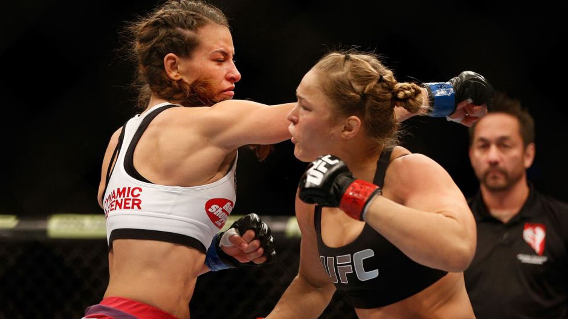 LAS VEGAS, NV - DECEMBER 28: (L-R) Miesha Tate punches Ronda Rousey in their UFC women's bantamweight championship bout during the UFC 168 event at the MGM Grand Garden Arena on December 28, 2013 in Las Vegas, Nevada. (Photo by Josh Hedges/Zuffa LLC/Zuffa LLC via Getty Images) *** Local Caption *** Ronda Rousey; Miesha Tate