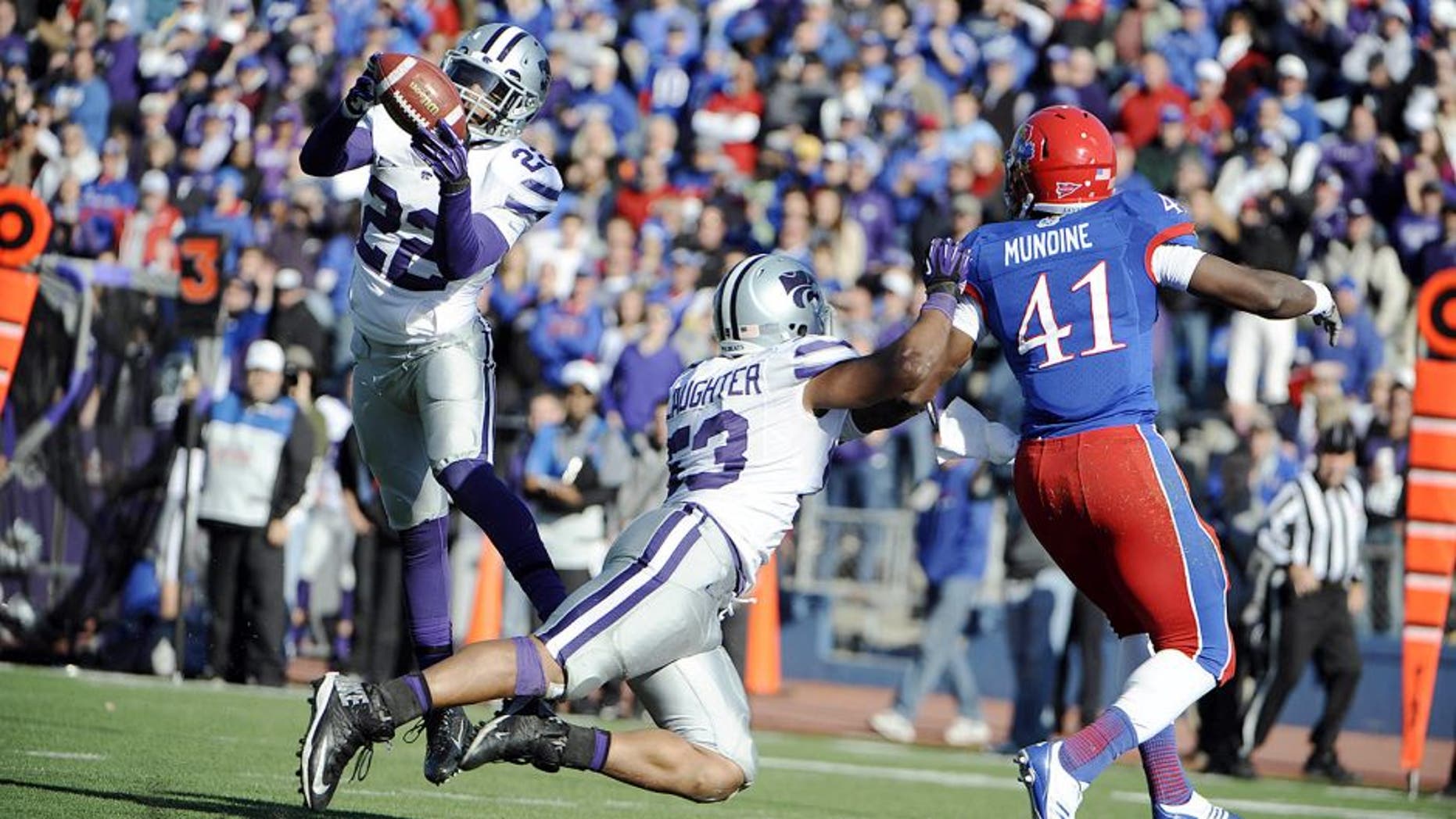 Nov 30, 2013; Lawrence, KS, USA; Kansas State Wildcats defensive back Dante Barnett (22) intercepts a pass intended for Kansas Jayhawks tight end Jimmay Mundine (41) as linebacker Blake Slaughter (53) defends in the second half at Memorial Stadium. Kansas State won the game 31-10. Mandatory Credit: John Rieger-USA TODAY Sports