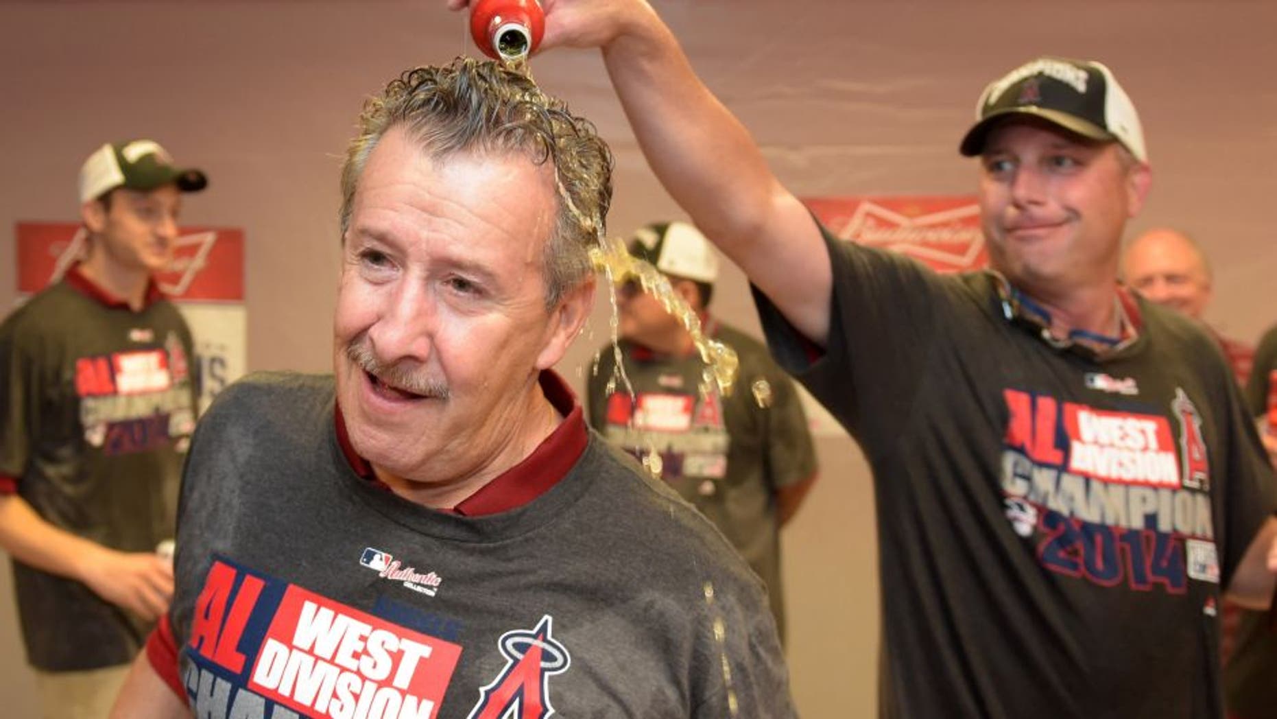 Sep 17, 2014; Anaheim, CA, USA; Los Angeles Angels owner Arte Moreno (left) celebrates with third base coach Gary DiSarcina after winning the American League West Division title against the Seattle Mariners at Angel Stadium of Anaheim. Mandatory Credit: Kirby Lee-USA TODAY Sports