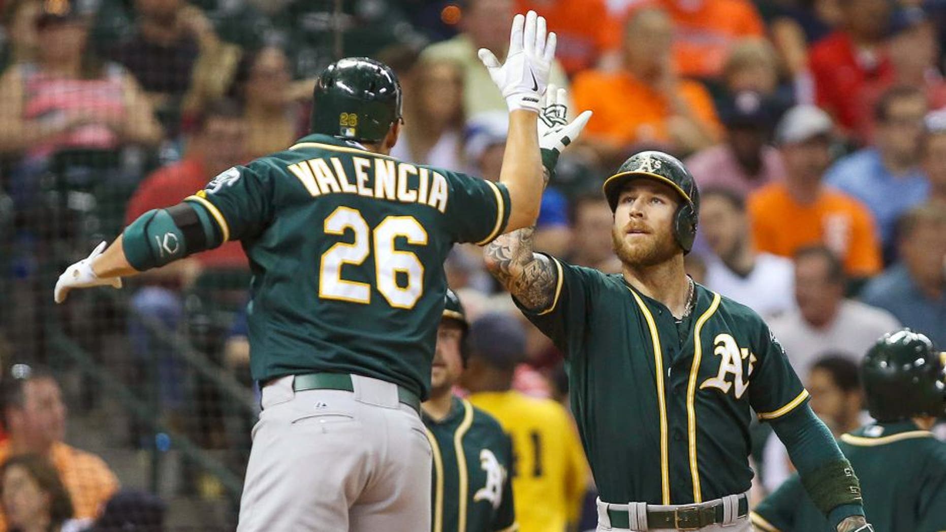 Sep 18, 2015; Houston, TX, USA; Oakland Athletics third baseman Danny Valencia (26) celebrates with second baseman Brett Lawrie (15) after hitting a home run during the fourth inning against the Houston Astros at Minute Maid Park. Mandatory Credit: Troy Taormina-USA TODAY Sports