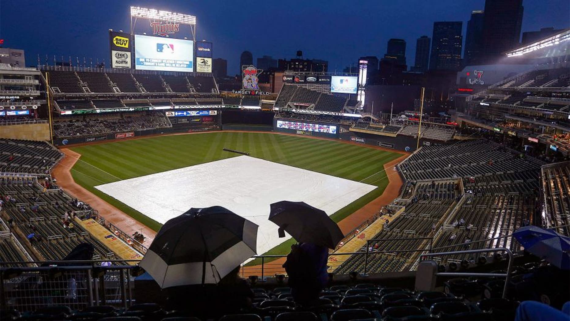 Sep 18, 2015; Minneapolis, MN, USA; Fans hide under umbrellas as rain delays the game between the Los Angeles Angels and the Minnesota Twins at Target Field. Mandatory Credit: Bruce Kluckhohn-USA TODAY Sports