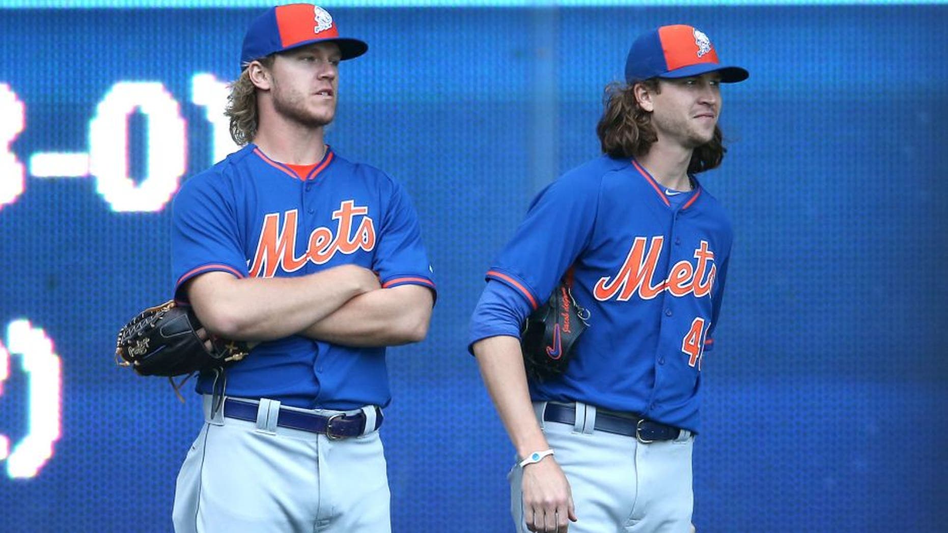 TORONTO, CANADA - JUNE 17: Noah Syndergaard #34 and Jacob deGrom #48 of the New York Mets look on from the outfield during batting practice before the start of the MLB game against the Toronto Blue Jays on June 17, 2015 at Rogers Centre in Toronto, Ontario, Canada. (Photo by Tom Szczerbowski/Getty Images)