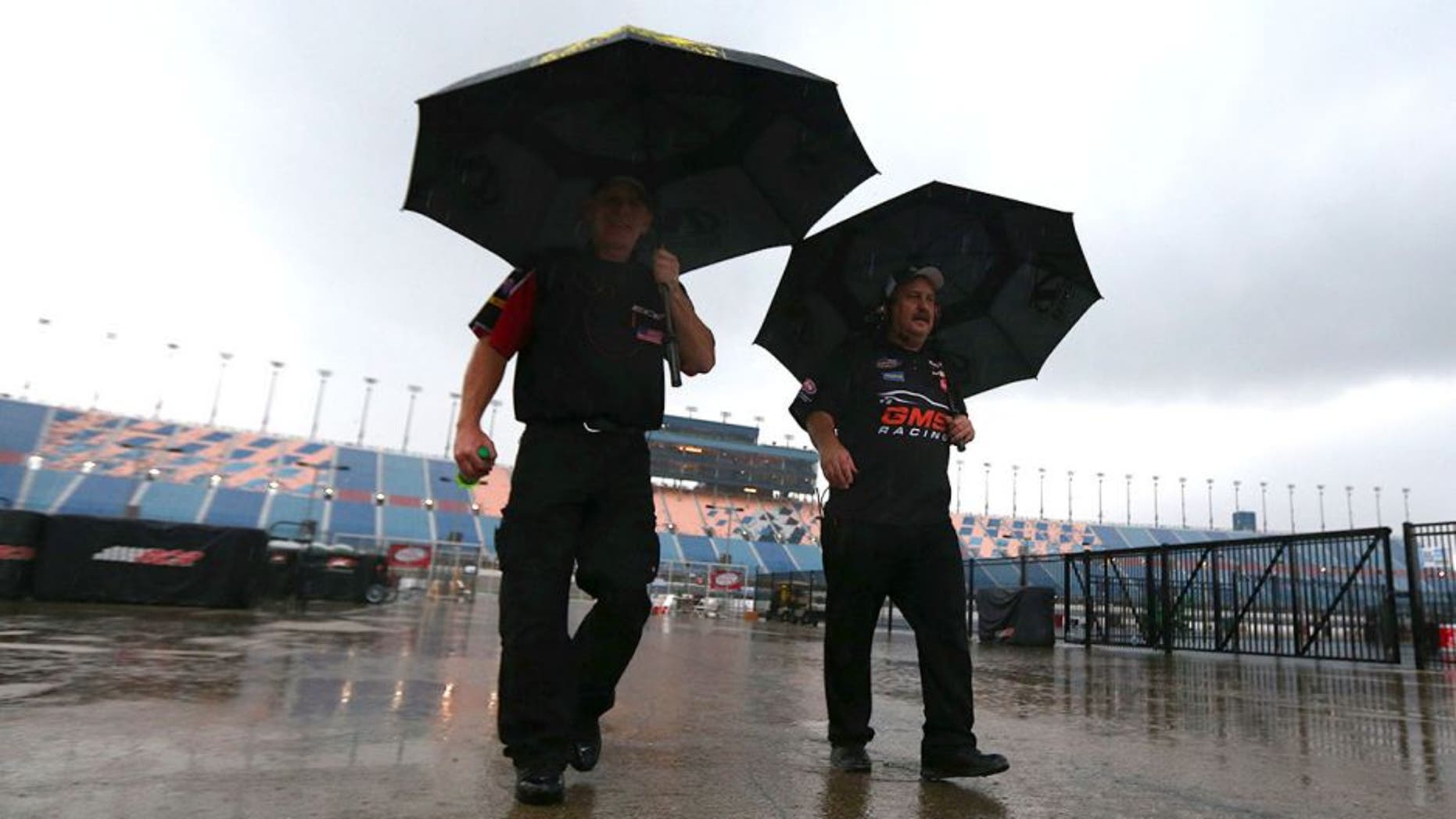 JOLIET, IL - SEPTEMBER 18: Crew members walk off pit road under heavy rain during qualifying for the NASCAR Camping World Truck Series American Ethanol E15 225 at Chicagoland Speedway on September 18, 2015 in Joliet, Illinois. (Photo by Sarah Crabill/NASCAR via Getty Images)