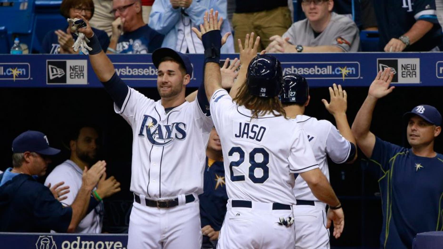 Sep 18, 2015; St. Petersburg, FL, USA; Tampa Bay Rays center fielder Mikie Mahtook (27) and designated hitter John Jaso (28) are congratulated by teammates as they scored during the fifth inning against the Baltimore Orioles and at Tropicana Field. Mandatory Credit: Kim Klement-USA TODAY Sports
