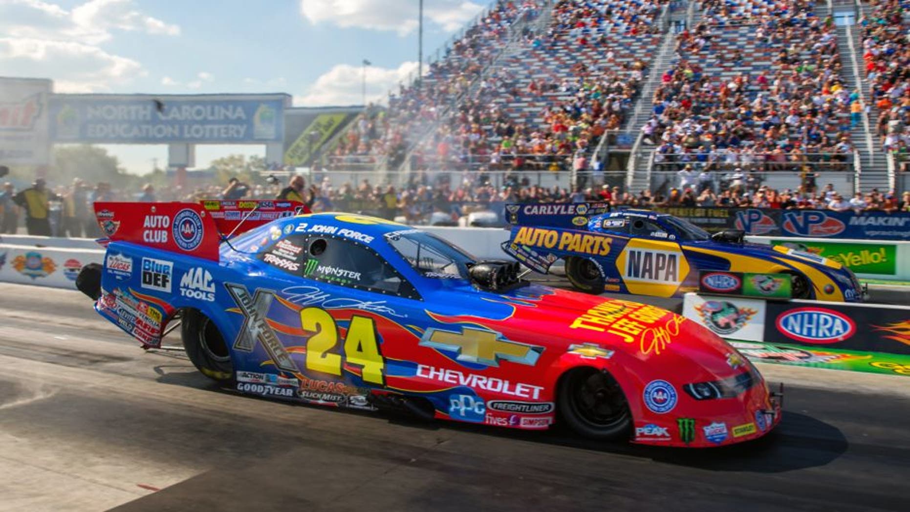 Sep 18, 2015; Concord, NC, USA; NHRA funny car driver John Force (near) in his special paint scheme honoring retiring NASCAR driver Jeff Gordon as he races alongside Ron Capps during qualifying for the Carolina Nationals at zMax Dragway. Mandatory Credit: Mark J. Rebilas-USA TODAY Sports