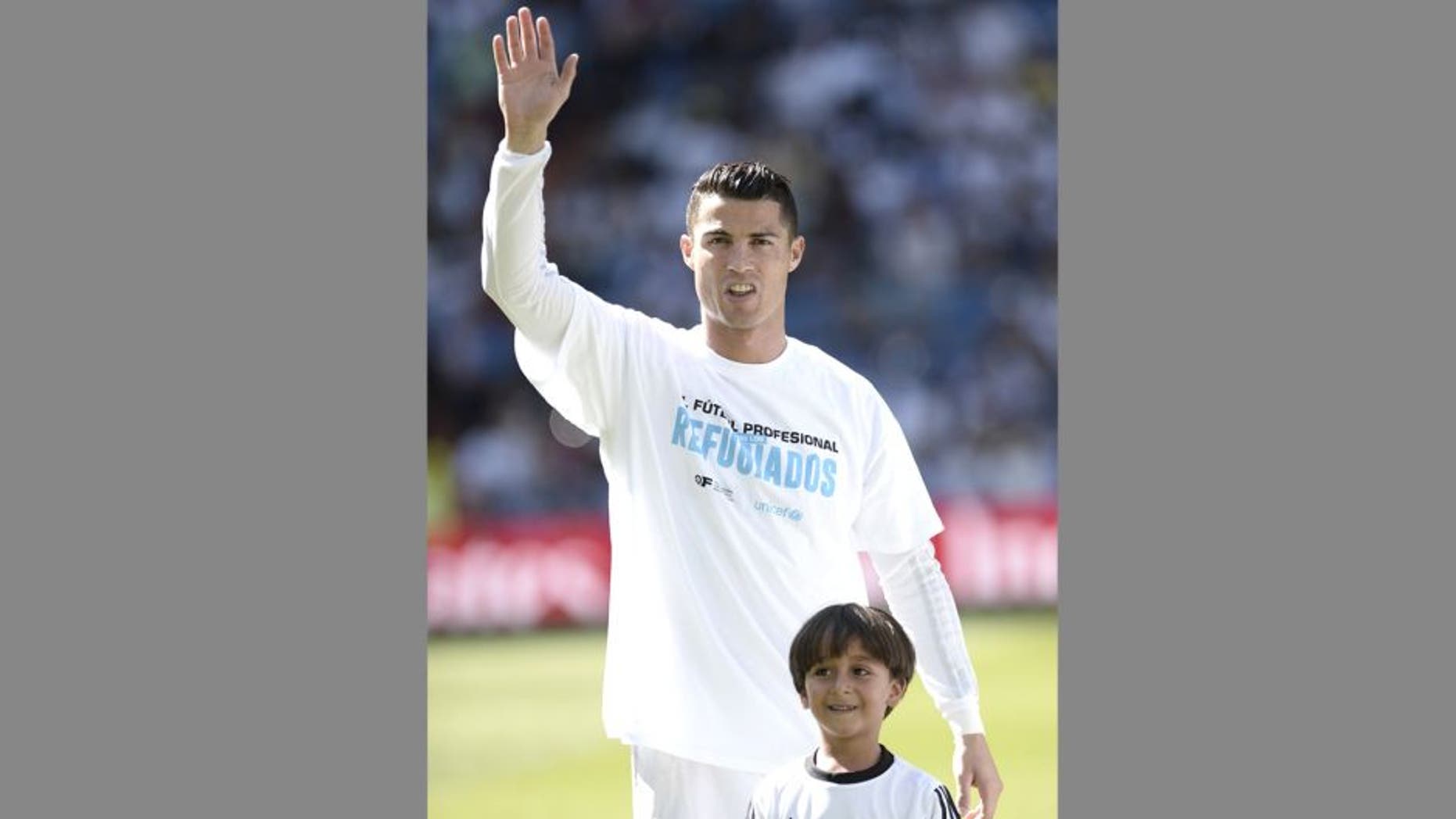 MADRID, SPAIN - SEPTEMBER 19: Zaid (R), son of Osama Abdul Mohsen (not seen), the Syrian refugee who had tripped over by a Hungarian journalist, pose with Cristiano Ronaldo (L) of Real Madrid before La Liga football match between Real Madrid CF vs Granada FC as the guests of Real Madrid CF at the Santiago Bernabeu stadium in Madrid on September 19, 2015. (Photo by Burak Akbulut/Anadolu Agency/Getty Images)