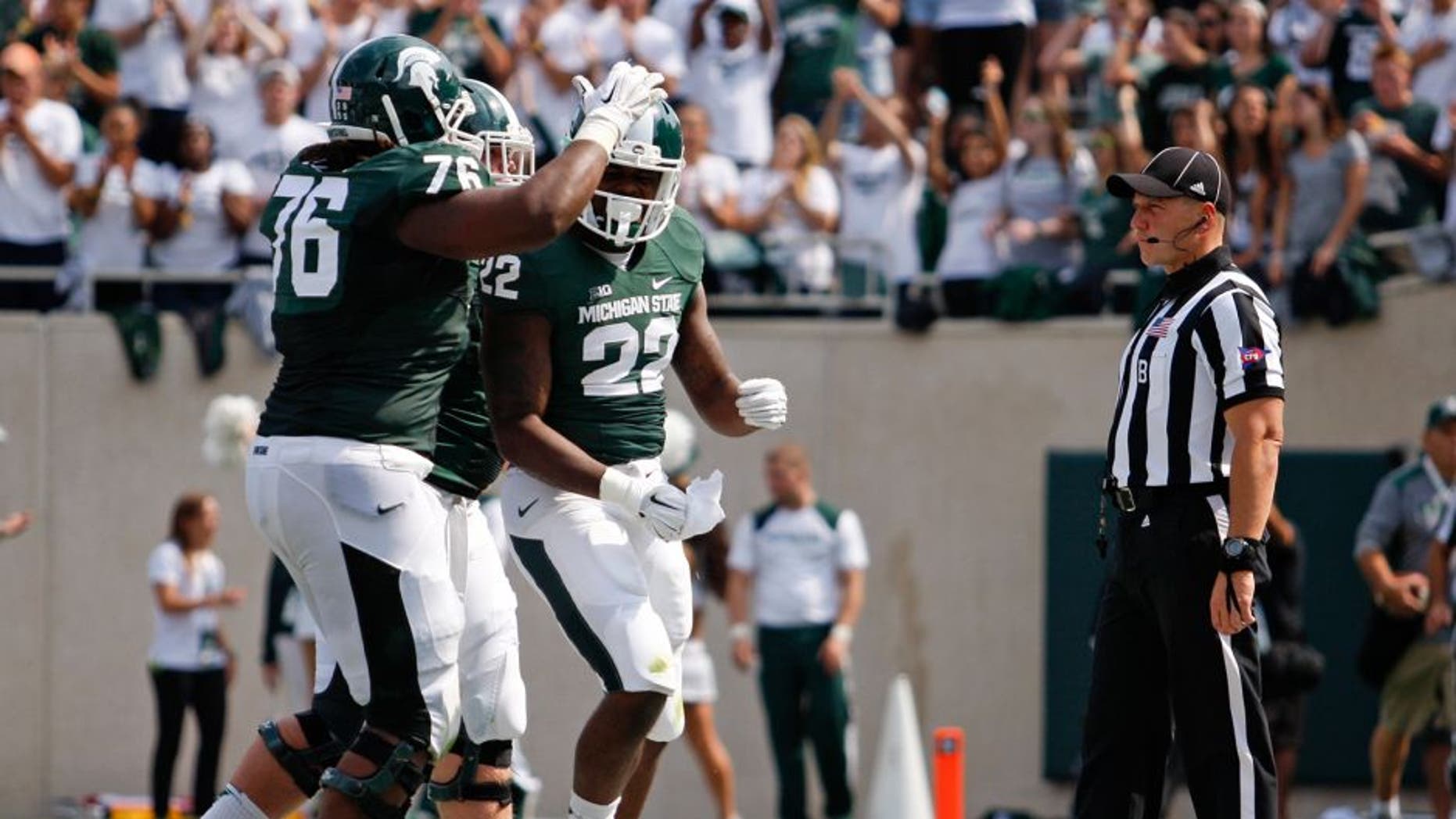 Sep 20, 2014; East Lansing, MI, USA; Michigan State Spartans running back Delton Williams (22) celebrates after a touchdown during the second quarter against the Eastern Michigan Eagles at Spartan Stadium. Mandatory Credit: Raj Mehta-USA TODAY Sports