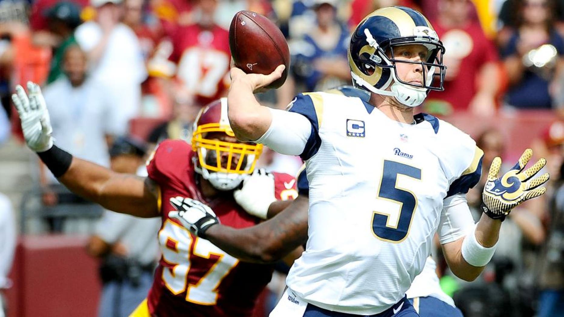 Sep 20, 2015; Landover, MD, USA; St. Louis Rams quarterback Nick Foles (5) attempts a pass as Washington Redskins defensive end Jason Hatcher (97) rushes during the first half at FedEx Field. Mandatory Credit: Brad Mills-USA TODAY Sports