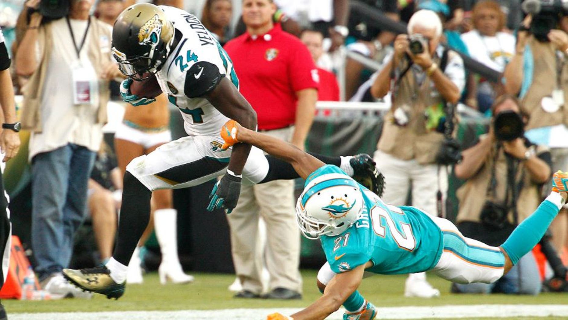 Sep 20, 2015; Jacksonville, FL, USA; Jacksonville Jaguars running back T.J. Yeldon (24) runs past Miami Dolphins cornerback Brent Grimes (21) during the second half of an NFL Football game at EverBank Field. The Jacksonville Jaguars won 23-20. Mandatory Credit: Reinhold Matay-USA TODAY Sports