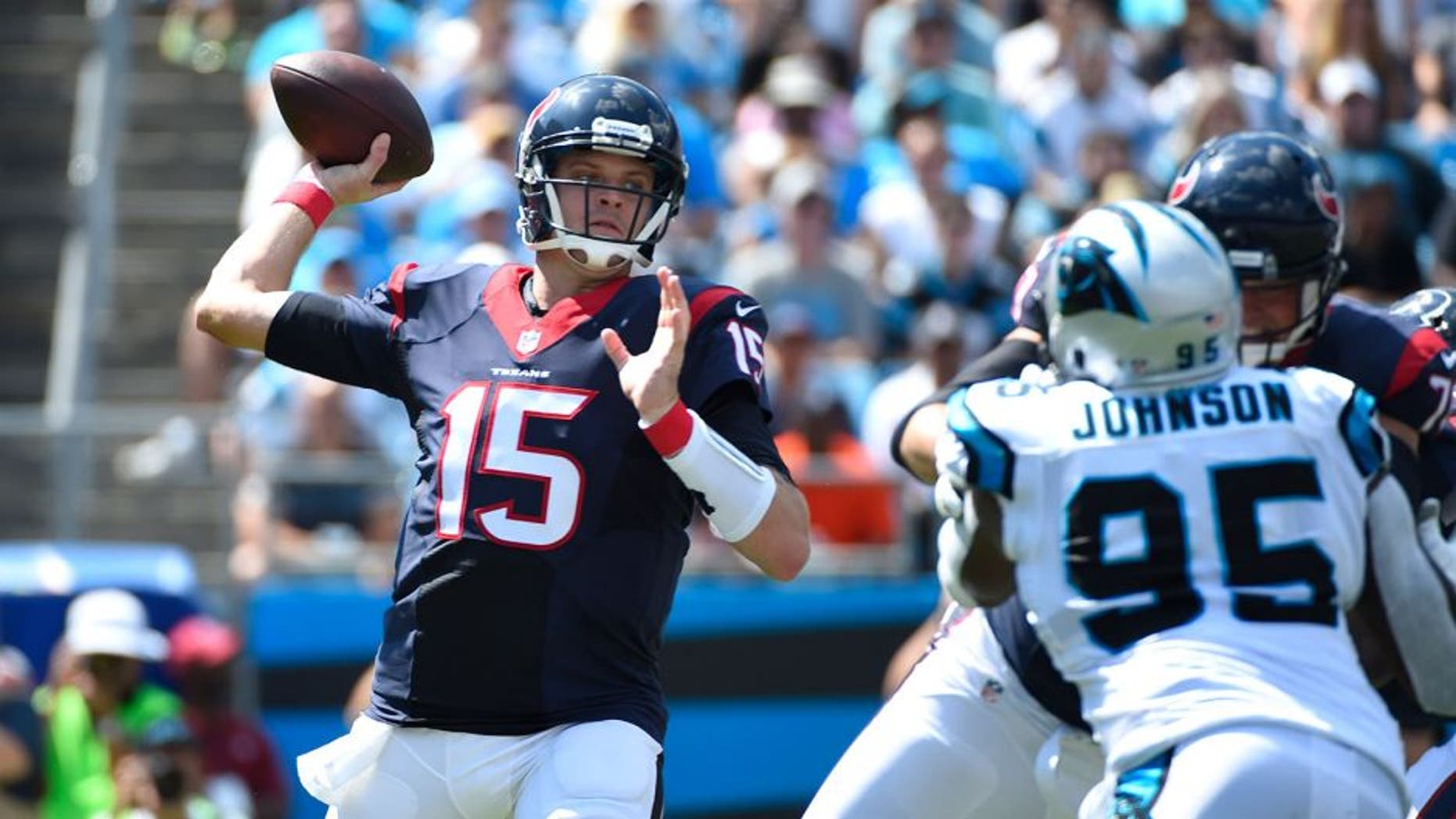 Sep 20, 2015; Charlotte, NC, USA; Houston Texans quarterback Ryan Mallett (15) looks to pass as Carolina Panthers defensive end Charles Johnson (95) defends in the first quarter at Bank of America Stadium. Mandatory Credit: Bob Donnan-USA TODAY Sports
