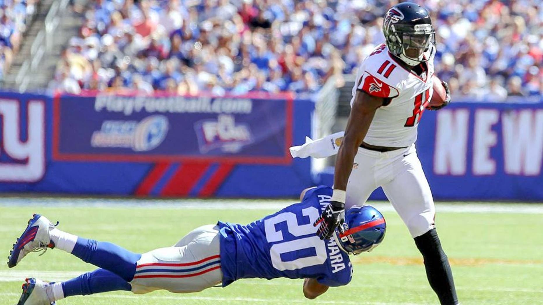 Sep 20, 2015; East Rutherford, NJ, USA; Atlanta Falcons wide receiver Julio Jones (11) runs with the ball while trying to avoid a tackle by New York Giants cornerback Prince Amukamara (20) during the first half at MetLife Stadium. Mandatory Credit: Ed Mulholland-USA TODAY Sports