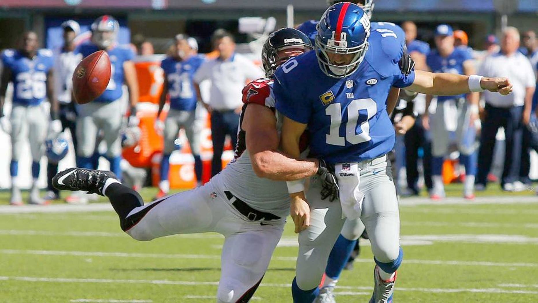 Sep 20, 2015; East Rutherford, NJ, USA; New York Giants quarterback Eli Manning (10) fumble s the ball after the tackle by Atlanta Falcons outside linebacker Kroy Biermann (71) during second half at MetLife Stadium. The Atlanta Falcons defeated the New York Giants 24-20. Mandatory Credit: Noah K. Murray-USA TODAY Sports