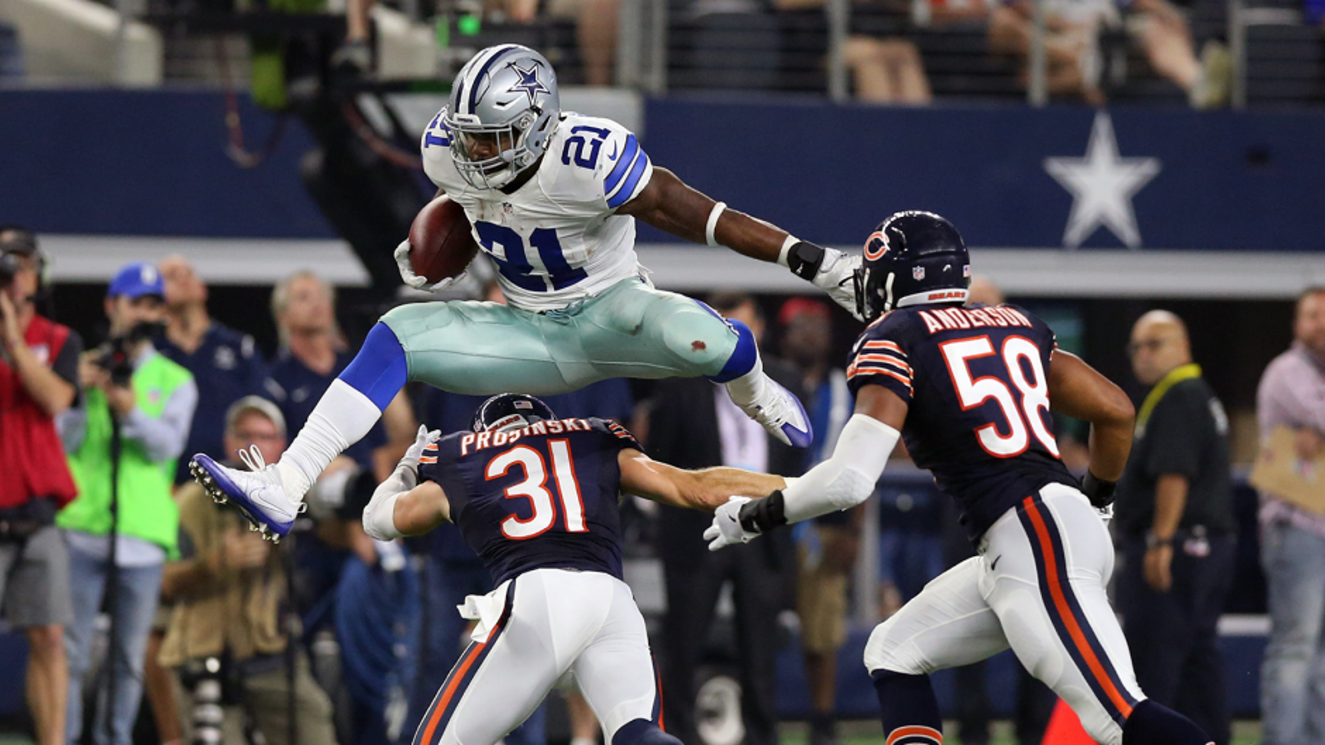 Sep 25, 2016; Arlington, TX, USA; Dallas Cowboys running back Ezekiel Elliott (21) leaps over Chicago Bears safety Chris Prosinski (31) in the fourth quarter at AT&T Stadium. Mandatory Credit: Matthew Emmons-USA TODAY Sports