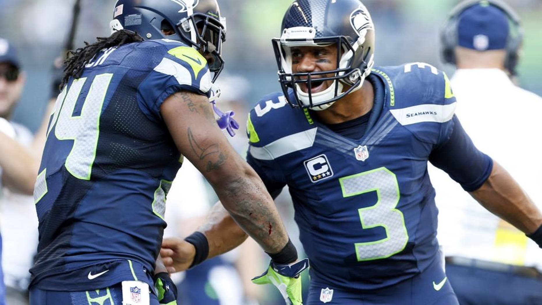 Sep 21, 2014; Seattle, WA, USA; Seattle Seahawks quarterback Russell Wilson (3) celebrates with Seattle Seahawks running back Marshawn Lynch (24) after a touchdown pass during the second quarter against the Denver Broncos at CenturyLink Field. Mandatory Credit: Joe Nicholson-USA TODAY Sports