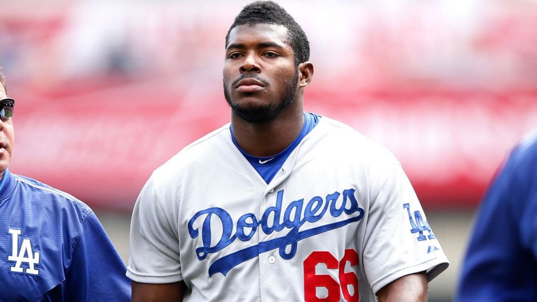 CINCINNATI, OH - AUGUST 27: Yasiel Puig #66 of the Los Angeles Dodgers walks off the field with director of medical services Stan Conte after suffering an injury during the game against the Cincinnati Reds at Great American Ball Park on August 27, 2015 in Cincinnati, Ohio. The Dodgers defeated the Reds 1-0. (Photo by Joe Robbins/Getty Images)