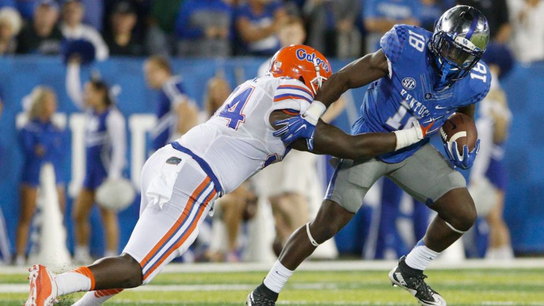 Sep 19, 2015; Lexington, KY, USA; Kentucky Wildcats running back Stanley Boom Williams (18) runs the ball against Florida Gators defensive lineman Bryan Cox (94) during the game at Commonwealth Stadium. Florida defeated Kentucky 14-9. Mandatory Credit: Mark Zerof-USA TODAY Sports