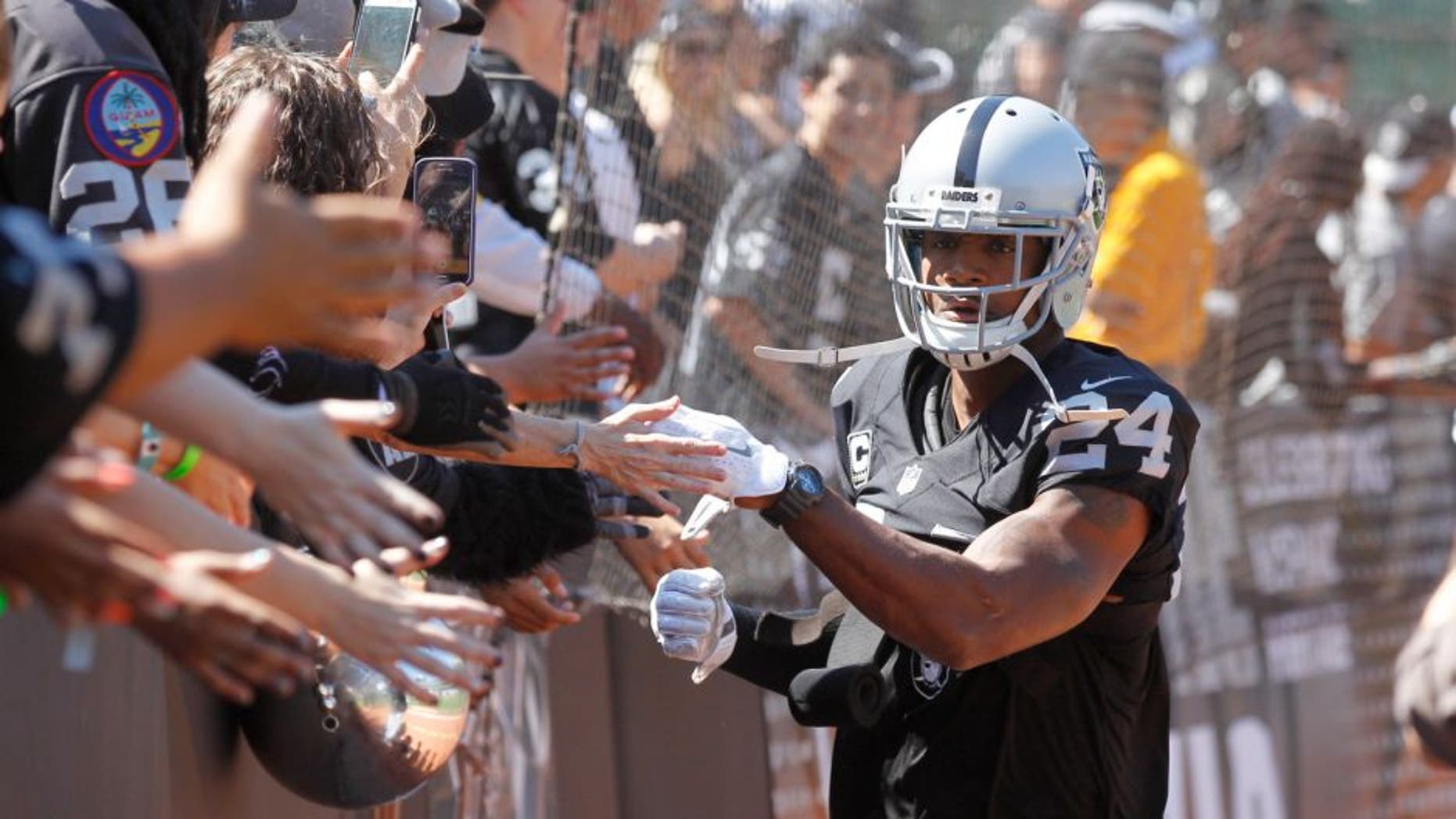 Sep 20, 2015; Oakland, CA, USA; Oakland Raiders free safety Charles Woodson (24) greets fans before the start of the game against the Baltimore Ravens at O.co Coliseum. Mandatory Credit: Cary Edmondson-USA TODAY Sports