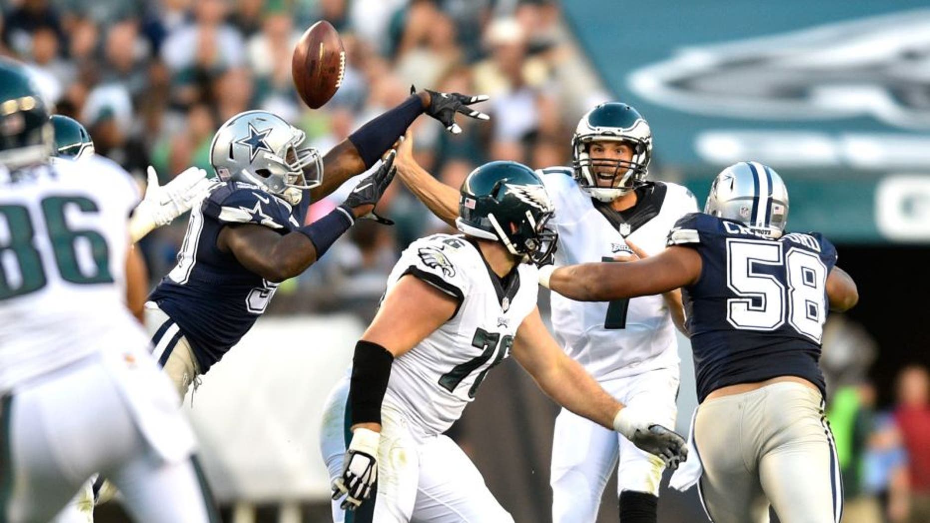 Sep 20, 2015; Philadelphia, PA, USA; Philadelphia Eagles quarterback Sam Bradford (7) has the ball tipped by Dallas Cowboys defensive lineman DeMarcus Lawrence (left) as defensive tackle Jack Crawford (58) defends in the third quarter at Lincoln Financial Field. Mandatory Credit: James Lang-USA TODAY Sports