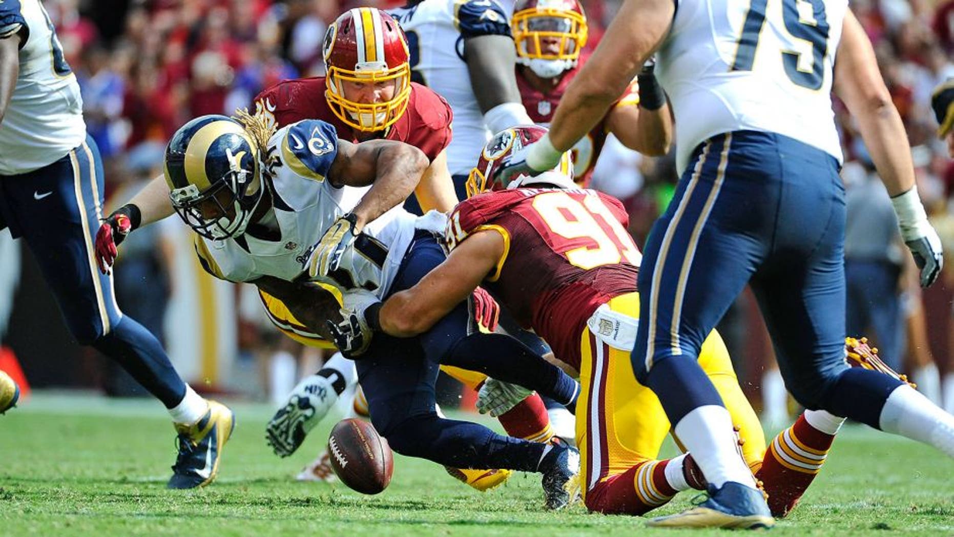 Sep 20, 2015; Landover, MD, USA; Washington Redskins outside linebacker Ryan Kerrigan (91) strips the ball from St. Louis Rams running back Tre Mason (27) during the second half at FedEx Field. The Washington Redskins won 24 - 10. Mandatory Credit: Brad Mills-USA TODAY Sports
