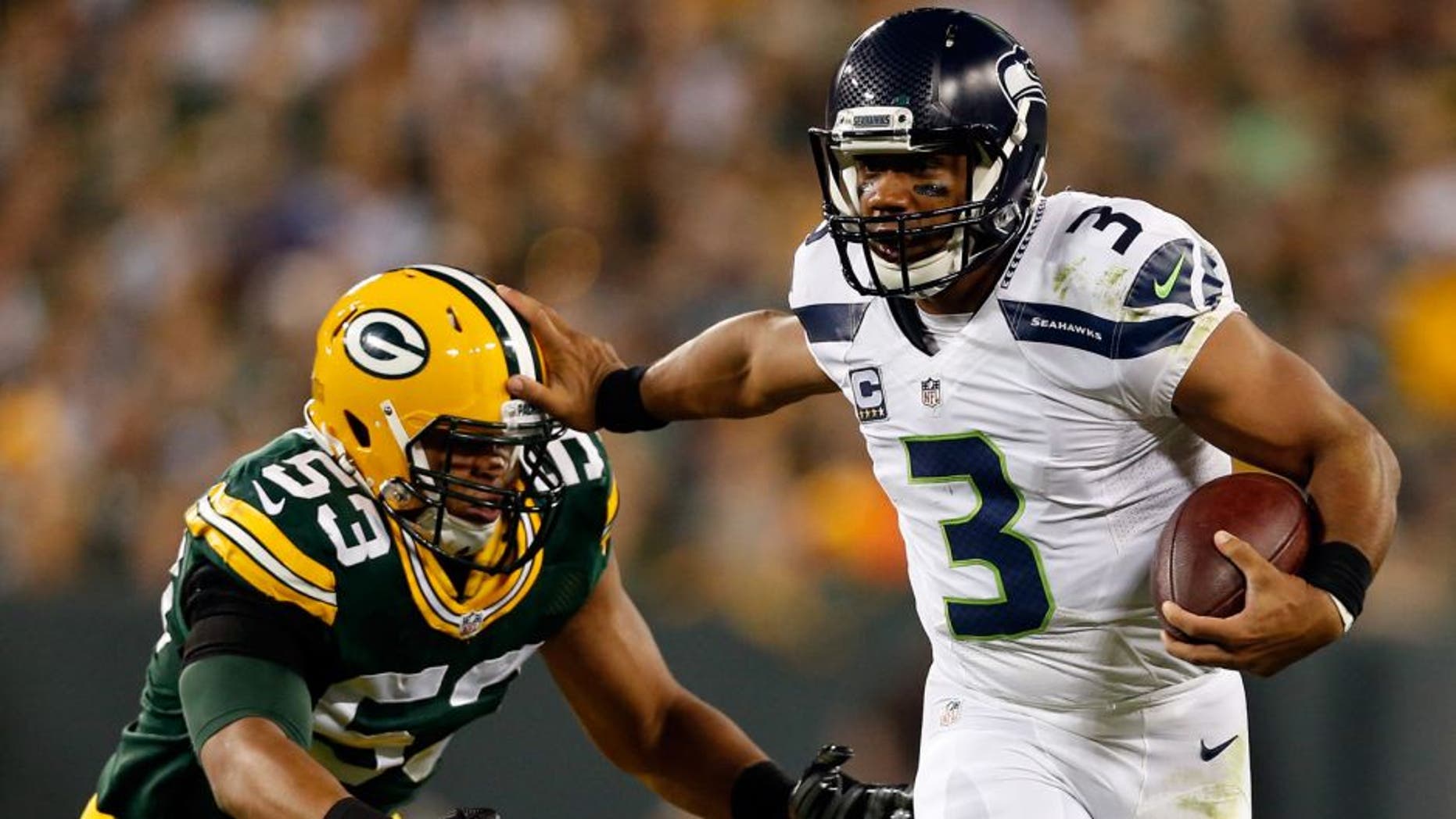 GREEN BAY, WI - SEPTEMBER 20: Russell Wilson #3 of the Seattle Seahawks stiff arms Nick Perry #53 of the Green Bay Packers during the third quarter in their game at Lambeau Field on September 20, 2015 in Green Bay, Wisconsin. (Photo by Christian Petersen/Getty Images)