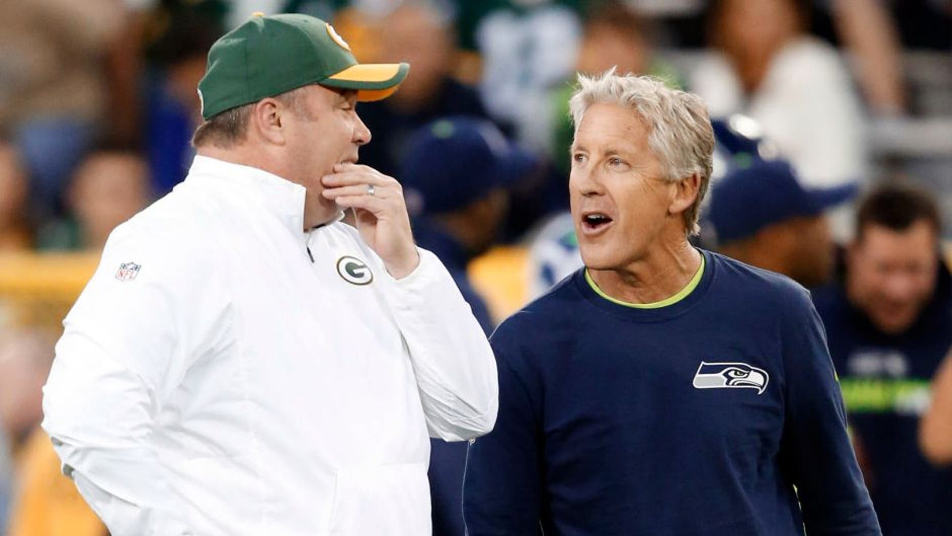 Green Bay Packers head coach Mike McCarthy (left) talks to Seattle Seahawks head coach Pete Carroll before an NFL football game Sunday, Sept. 20, 2015, in Green Bay, Wis.