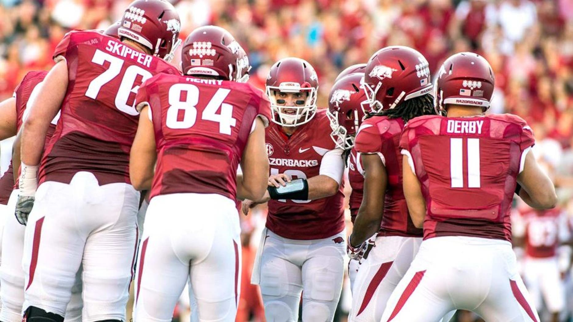 Sep 20, 2014; Fayetteville, AR, USA; Arkansas Razorbacks quarterback Brandon Allen (10, center) calls a play as offensive tackle Dan Skipper (74) tight end Henry Hunter (84) tightened A.J. Derby (11) and other players look on during the first half of a game against Northern Illinois Huskies at Donald W. Reynolds Razorback Stadium. Mandatory Credit: Beth Hall-USA TODAY Sports