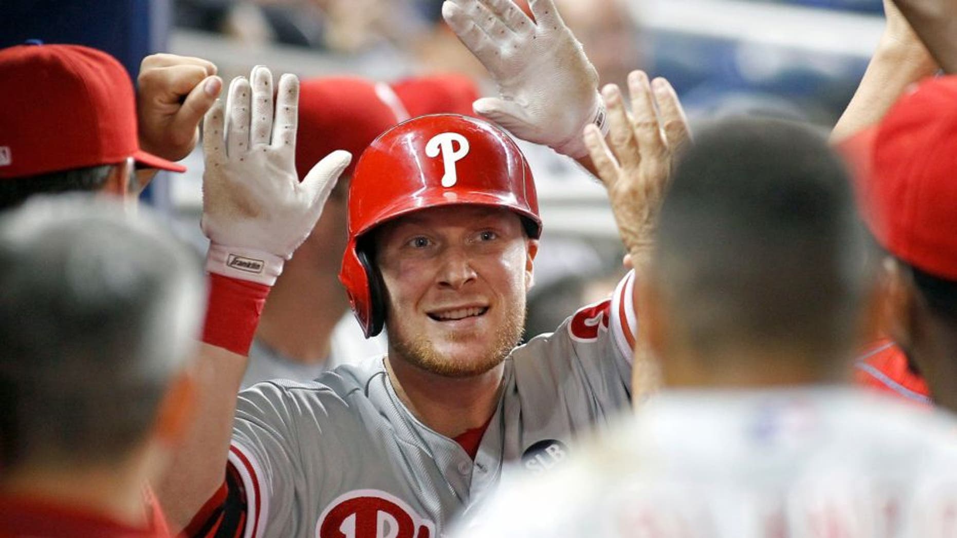 Philadelphia Phillies left fielder Cody Asche, center, is congratulated by teammates after his fourth inning home run against the Miami Marlins during a baseball game in Miami, Tuesday, Sept. 22, 2015. (AP Photo/Joe Skipper)