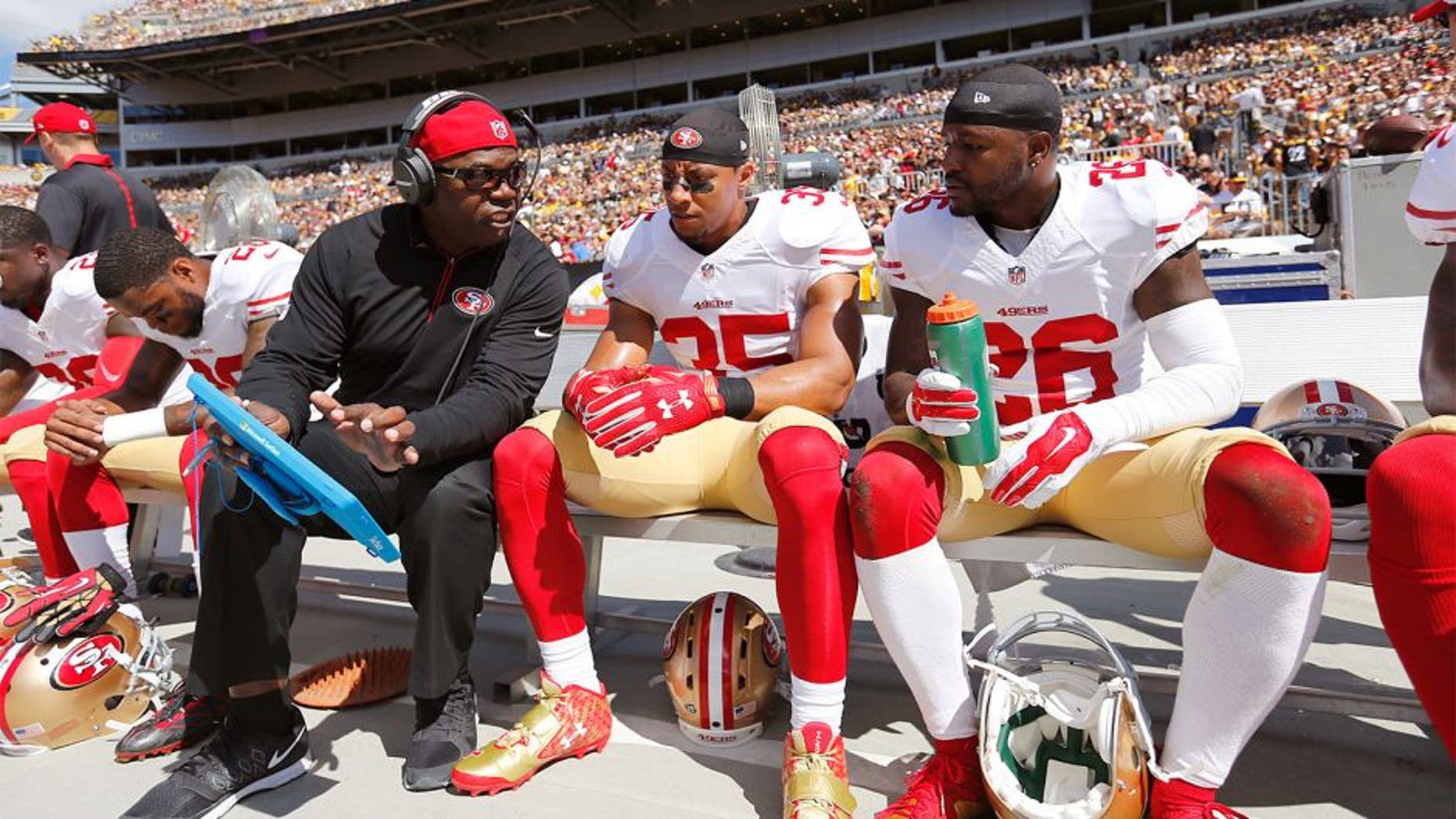 PITTSBURGH, PA - SEPTEMBER 20: Defensive Backs Coach Tim Lewis of the San Francisco 49ers talks with Eric Reid #35 and Tramaine Brock #26 on the sideline during the game against the Pittsburgh Steelers at Heinz Field on September 20, 2015 in Pittsburgh, Pennsylvania. The Steelers defeated the 49ers 43-18. (Photo by Michael Zagaris/San Francisco 49ers/Getty Images)