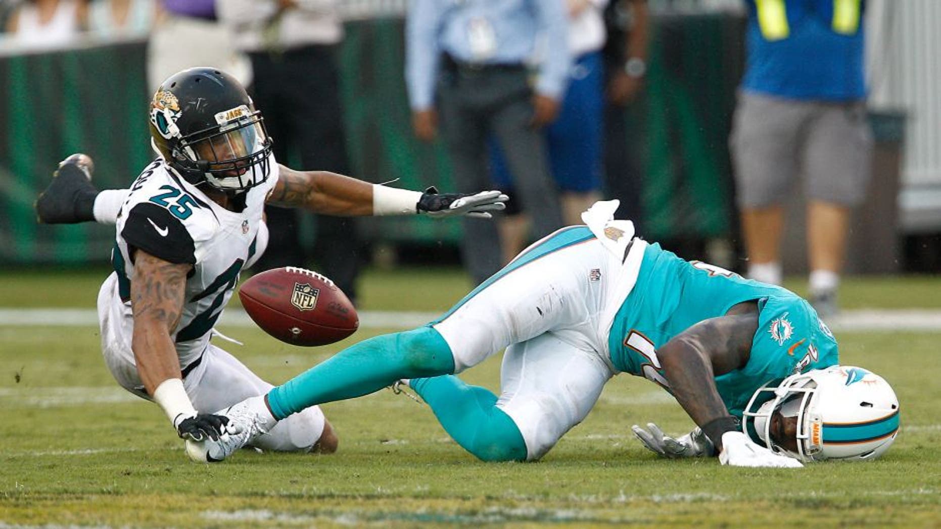 Sep 20, 2015; Jacksonville, FL, USA; Miami Dolphins wide receiver Jarvis Landry (14) can't hold onto the pass under pressure from Jacksonville Jaguars corner back Peyton Thompson (25) during the second half of an NFL Football game at EverBank Field. The Jacksonville Jaguars won 23-20. Mandatory Credit: Reinhold Matay-USA TODAY Sports