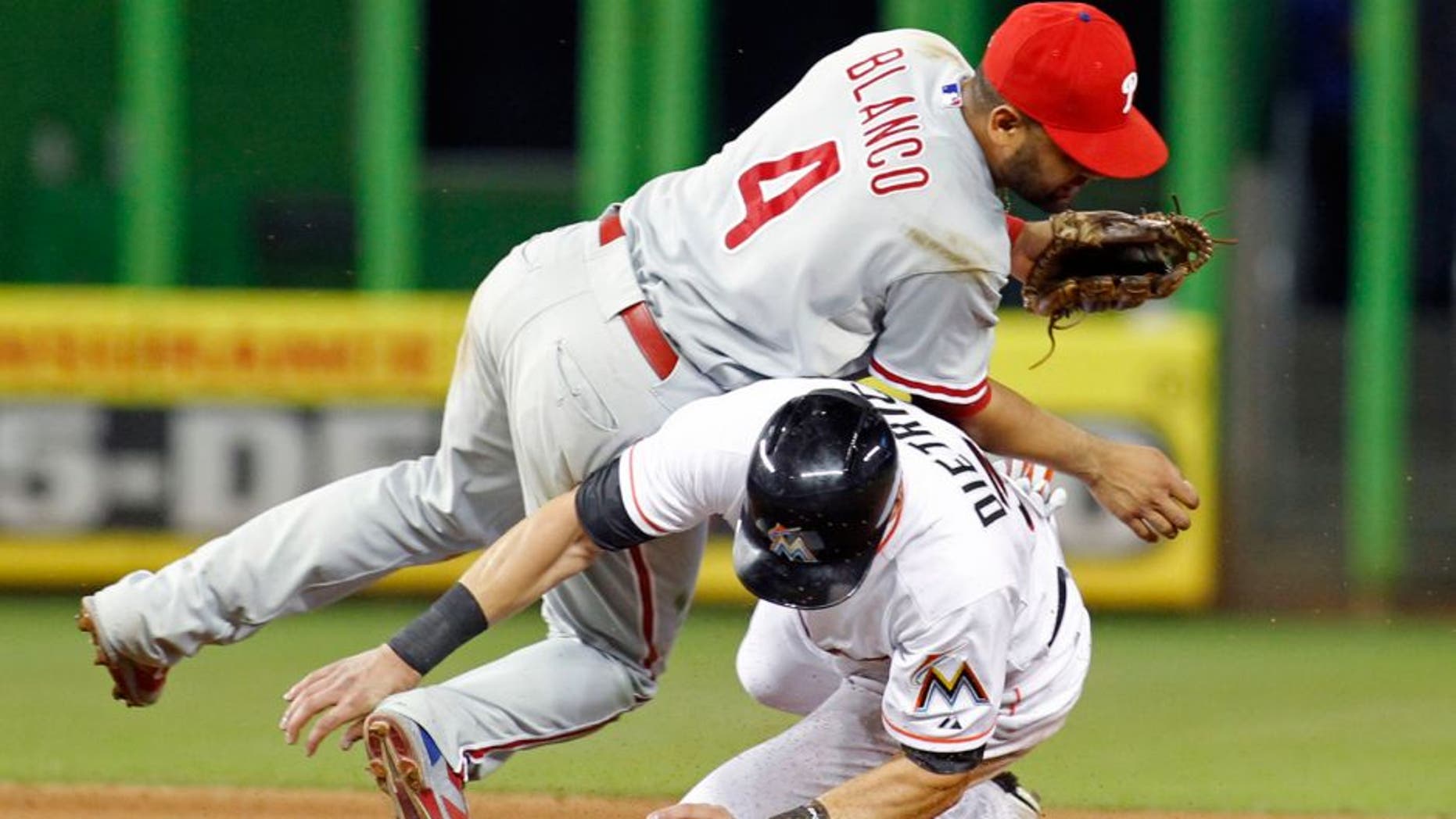 Miami Marlins base runner Derek Dietrich collides with Philadelphia Phillies second baseman Andres Blanco (4) after he was out at second base in a fourth inning double play during a baseball game in Miami, Tuesday, Sept. 22, 2015. (AP Photo/Joe Skipper)