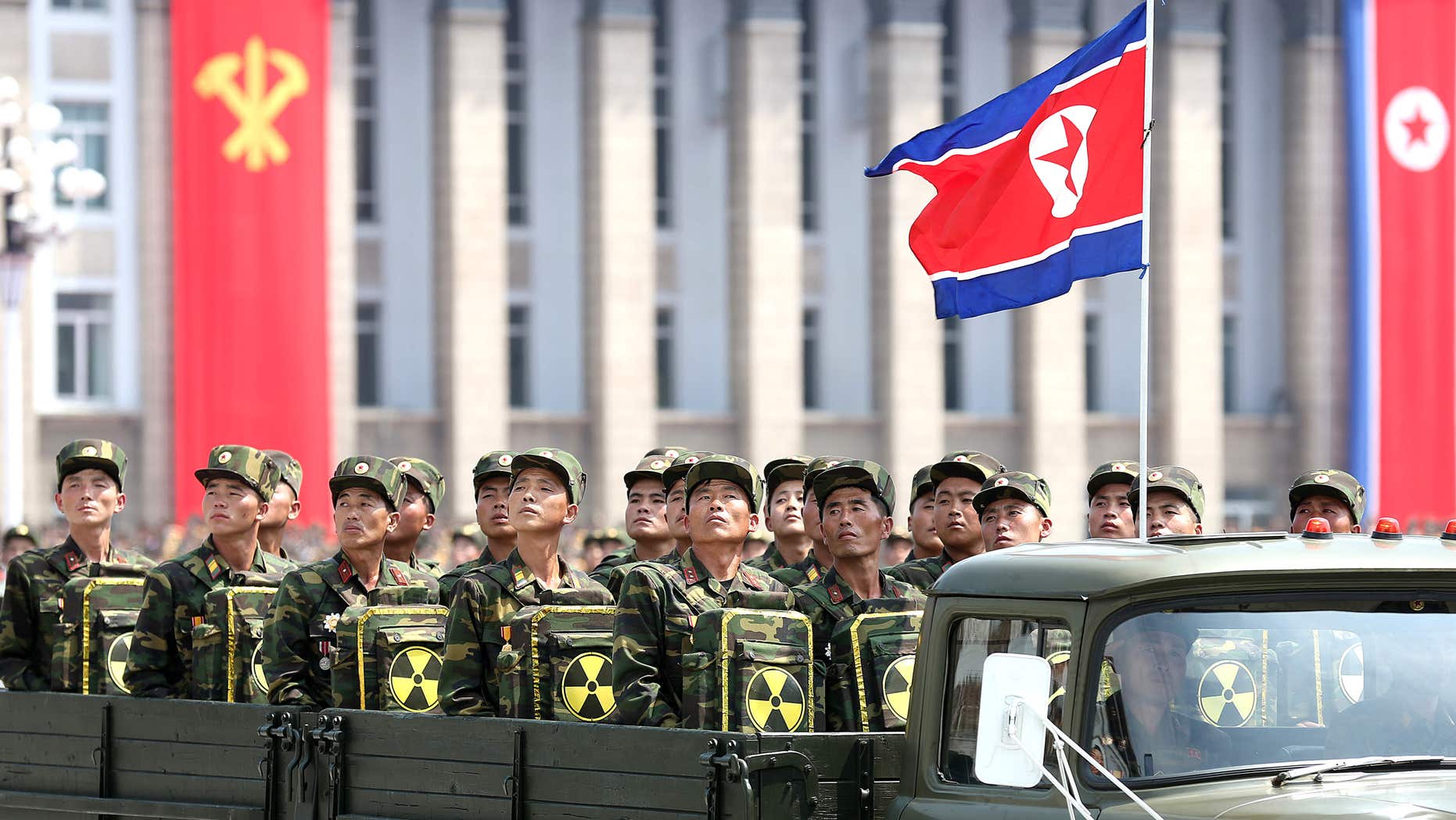 In this Saturday, July 27, 2013, file photo, North Korean soldiers turn and look towards leader Kim Jong Un as they carry packs marked with the nuclear symbol during a parade marking the 60th anniversary of the Korean War armistice in Pyongyang, North Korea.